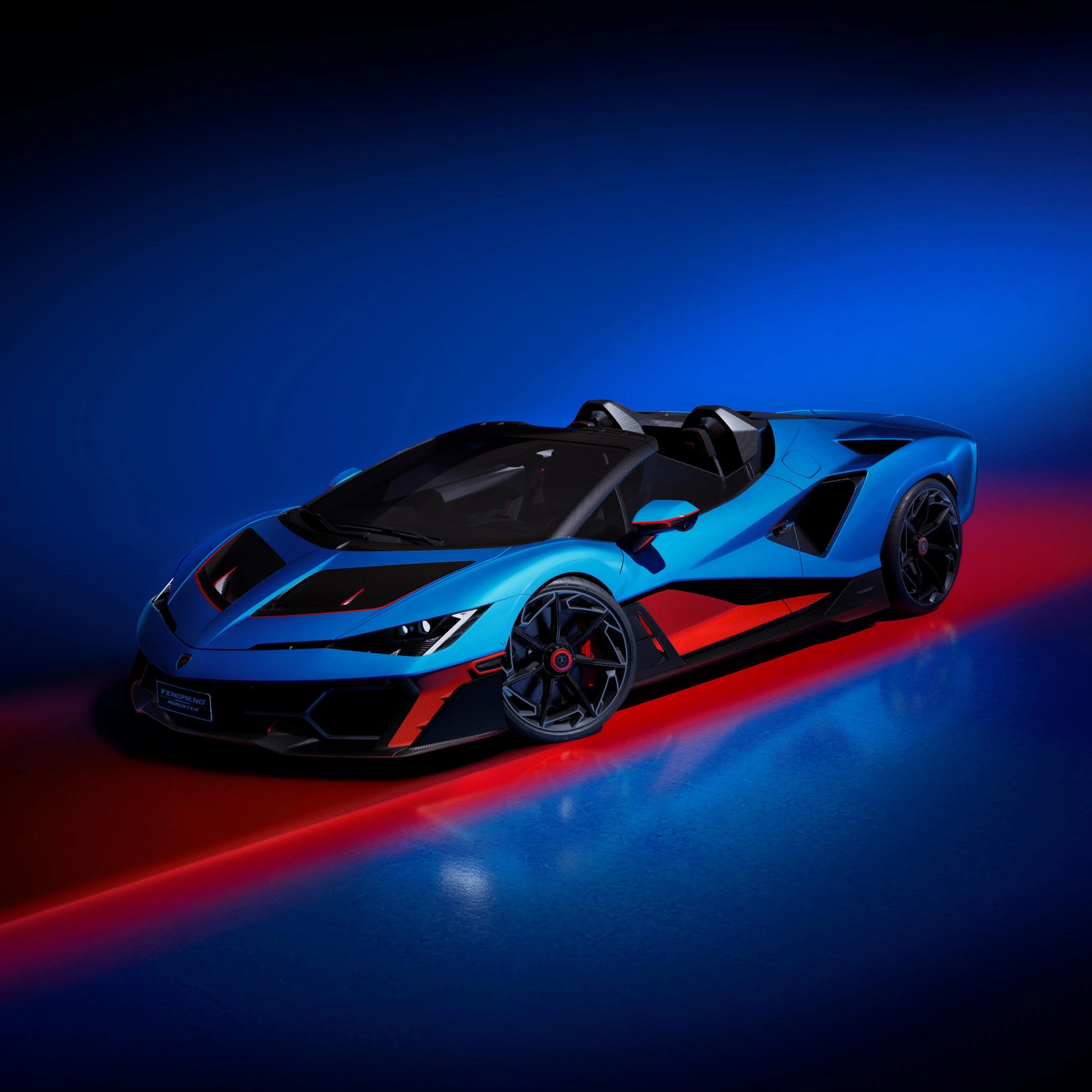 Blue and black Lamborghini Fenomeno Roadster with red accents on a blue and red lit floor.