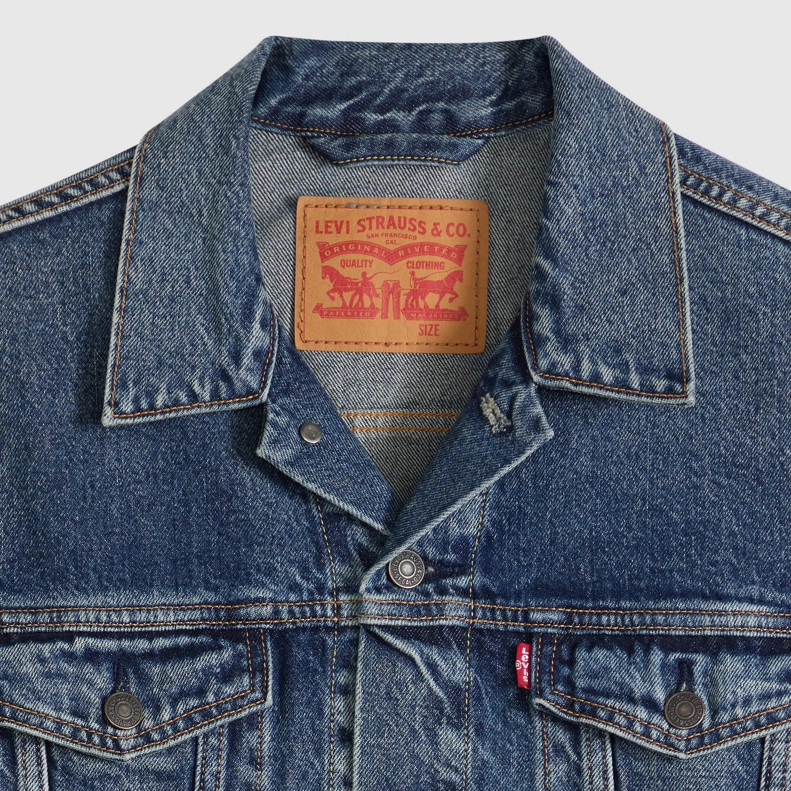 Blue denim Levi's jacket with brown leather brand patch and red Levi's tag on chest pocket.