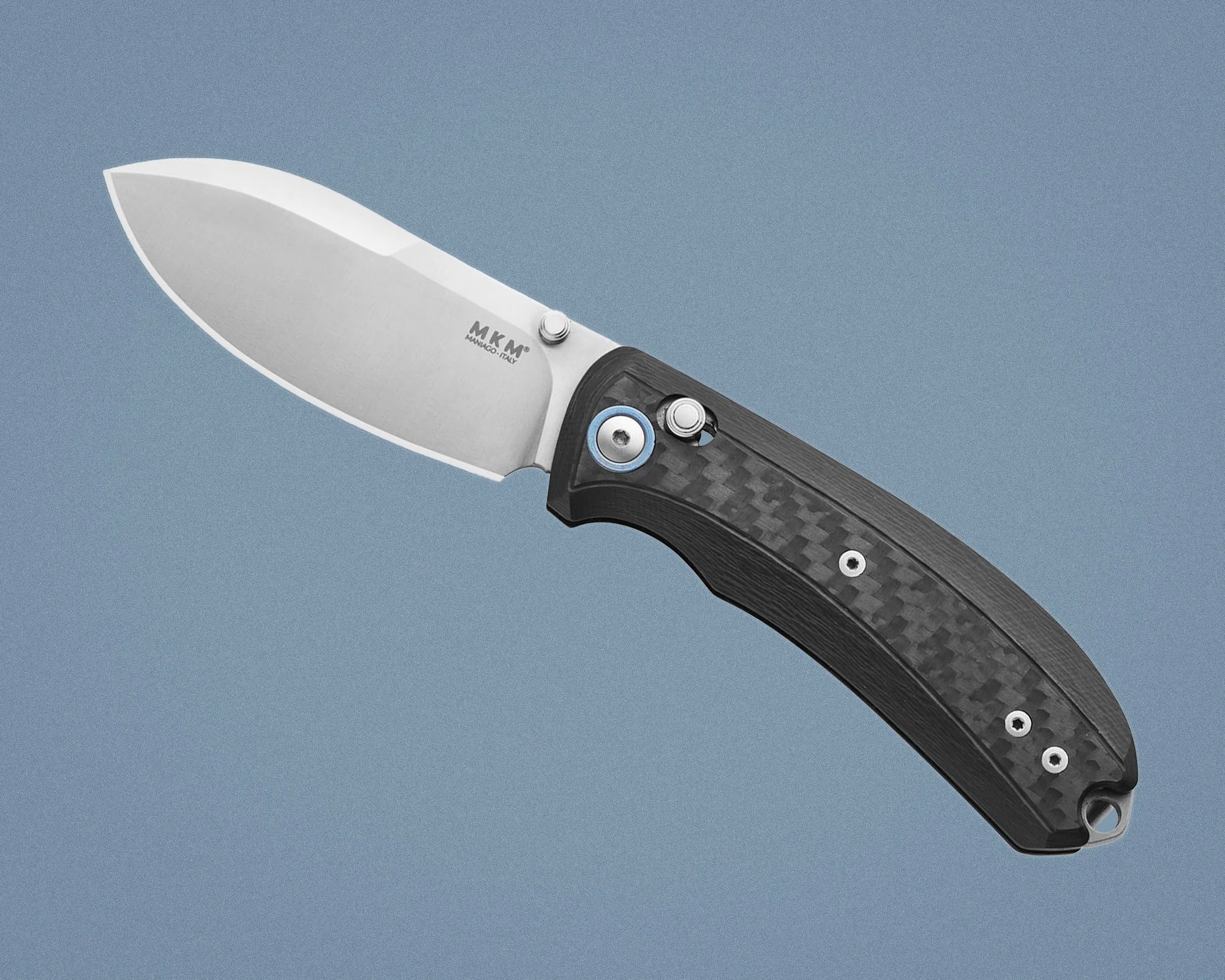 Folding knife with a stainless steel blade and black carbon fiber handle on a blue background.