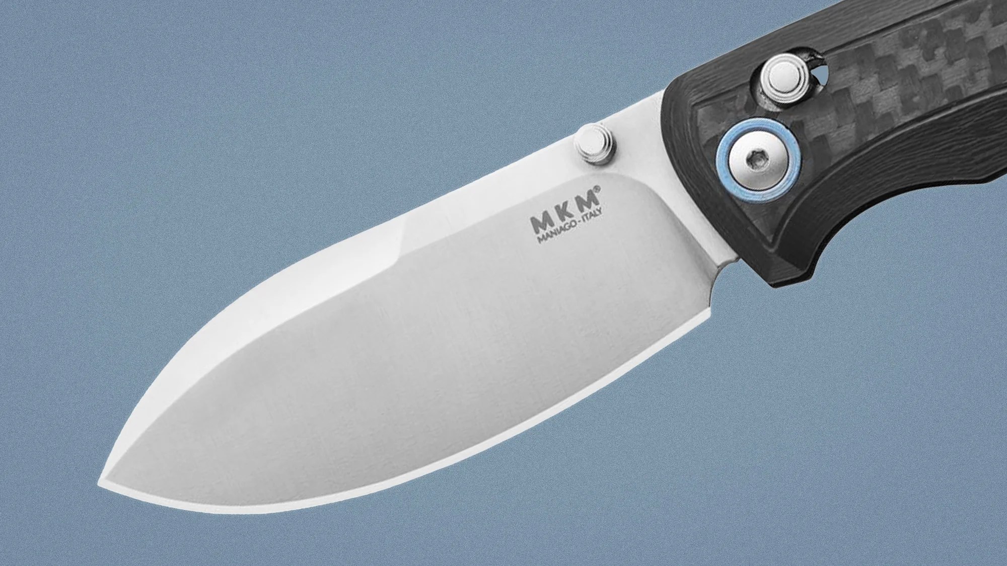 Close-up of a stainless steel MKM Manago-Italy knife blade with a black textured handle and blue accent.