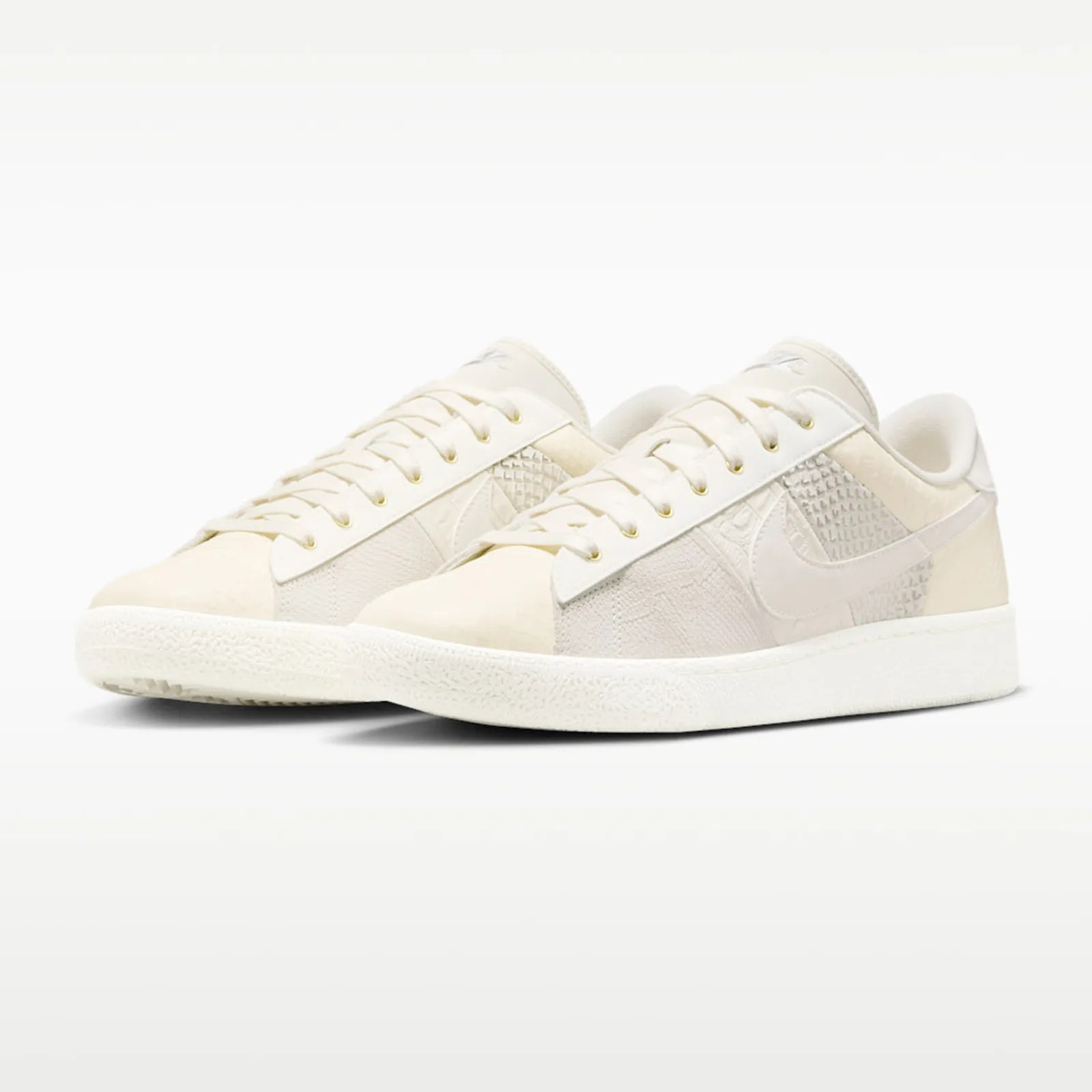 Pair of off-white low-top sneakers with textured panels and white rubber soles.
