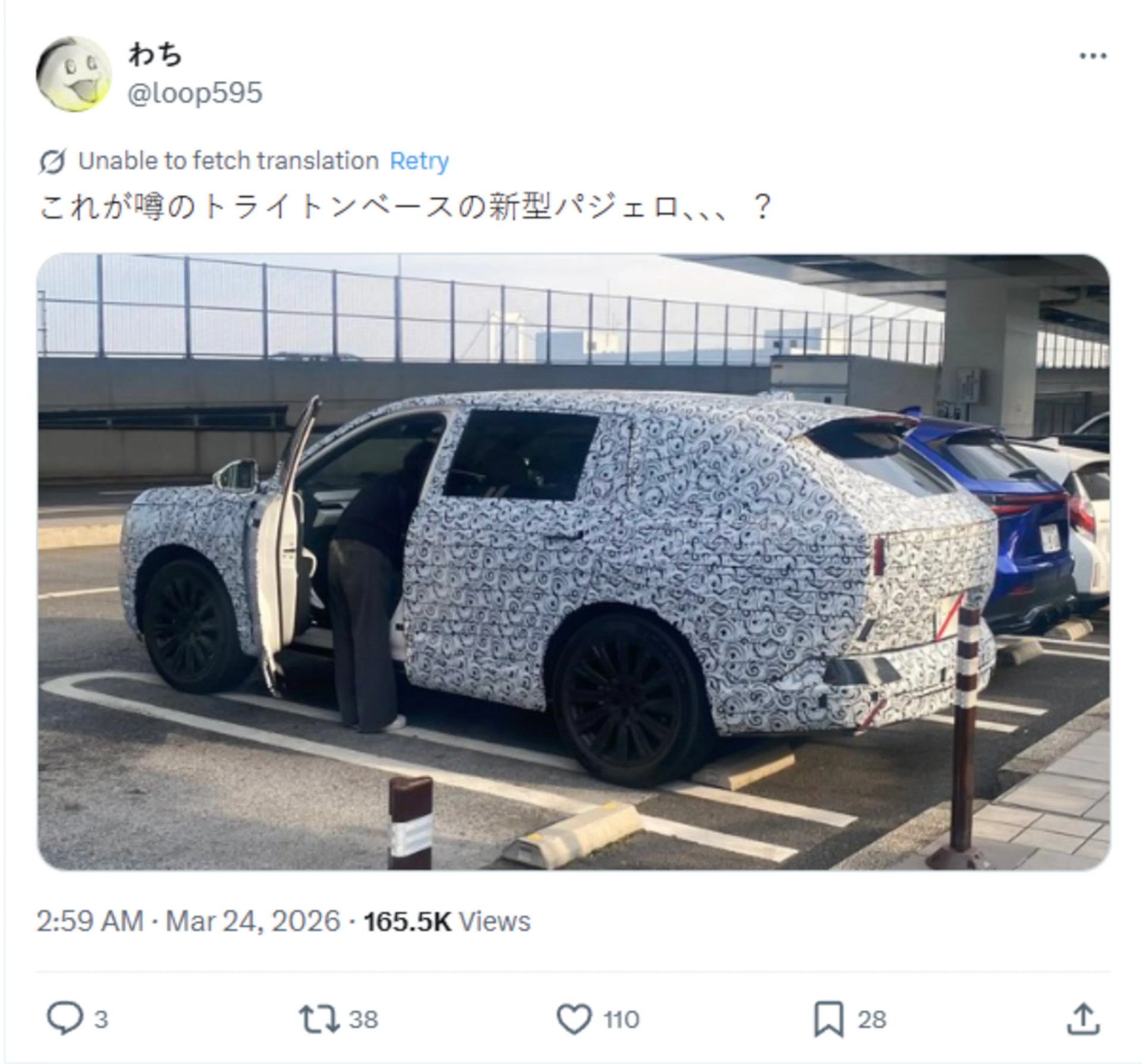 SUV covered in black and white camouflage wrap parked in a lot with the driver's door open and a person leaning inside.