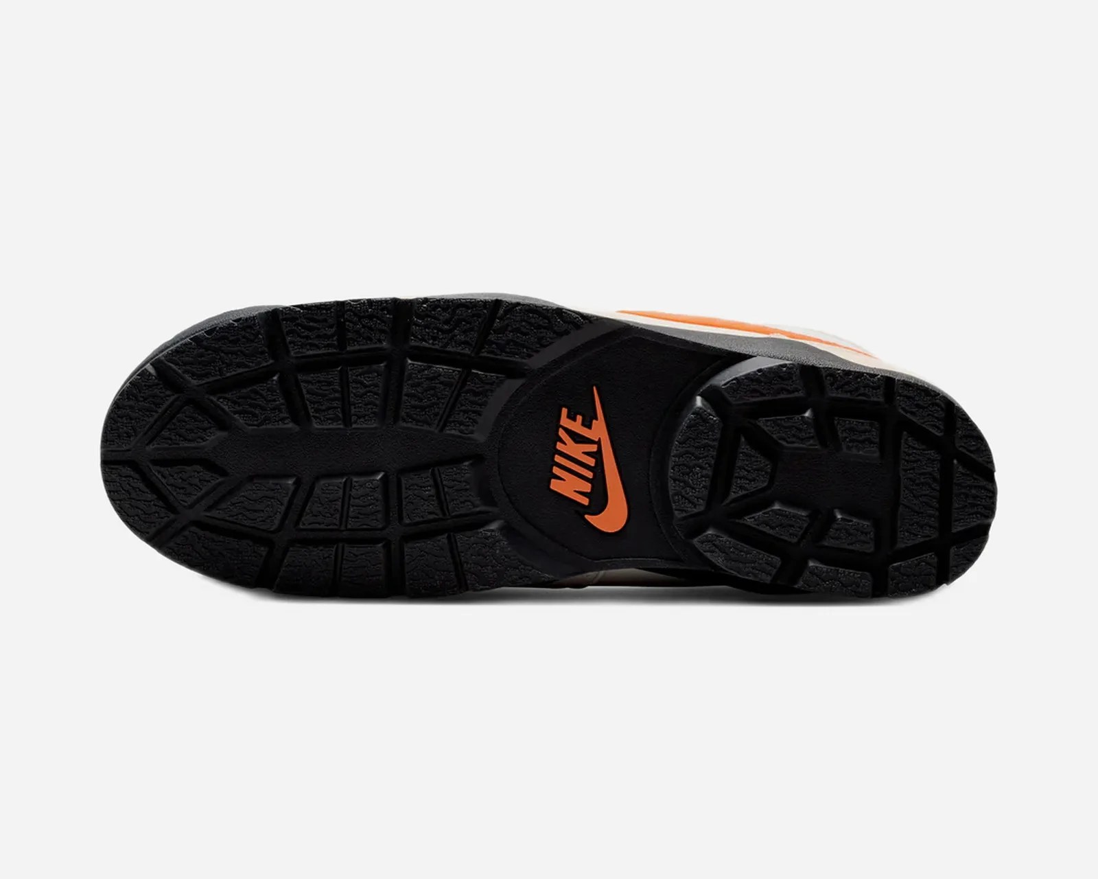 Black rubber sole of a Nike shoe with orange Nike logo in the center.