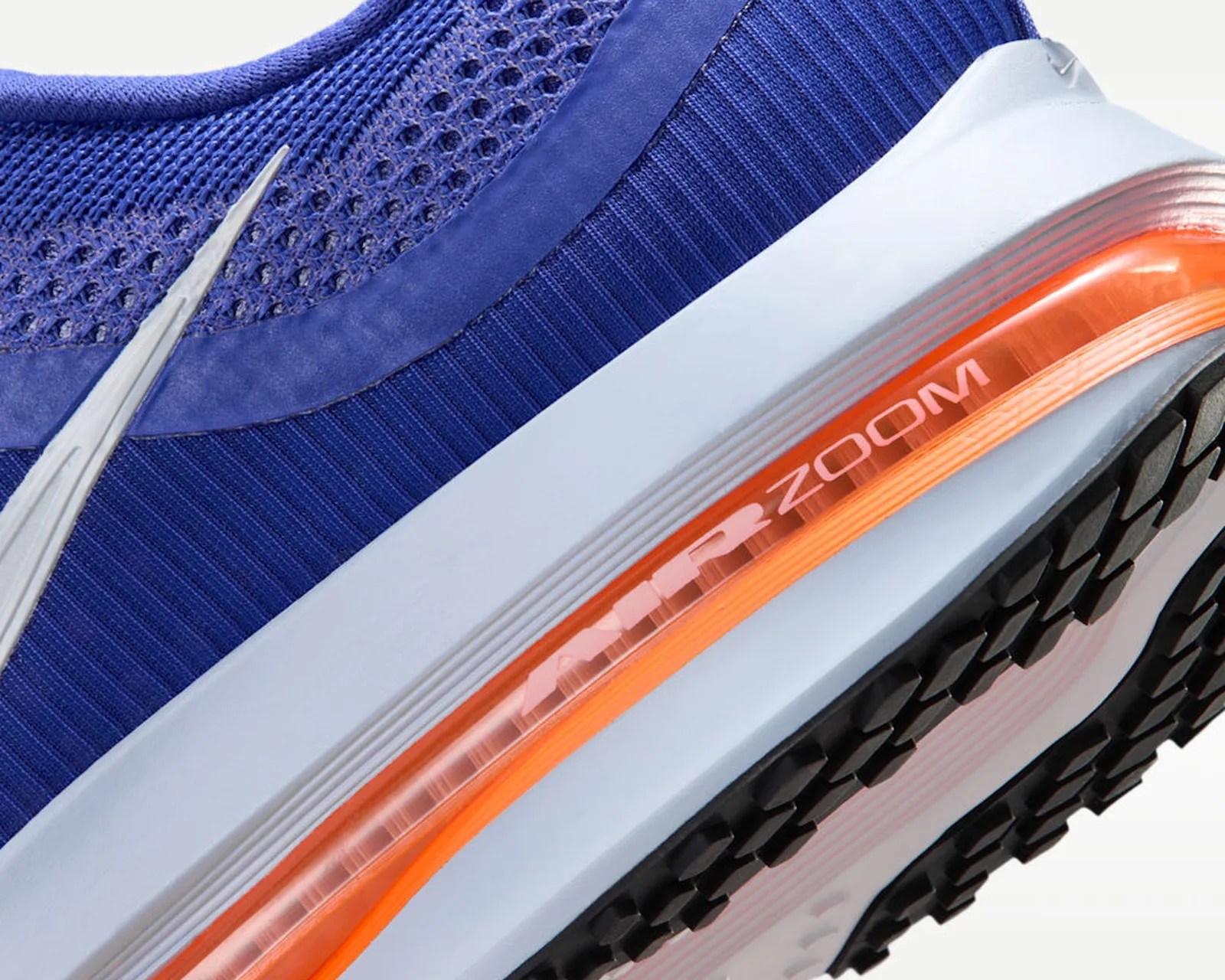 Close-up of a blue Nike Air Zoom shoe with white midsole and orange air cushion visible.