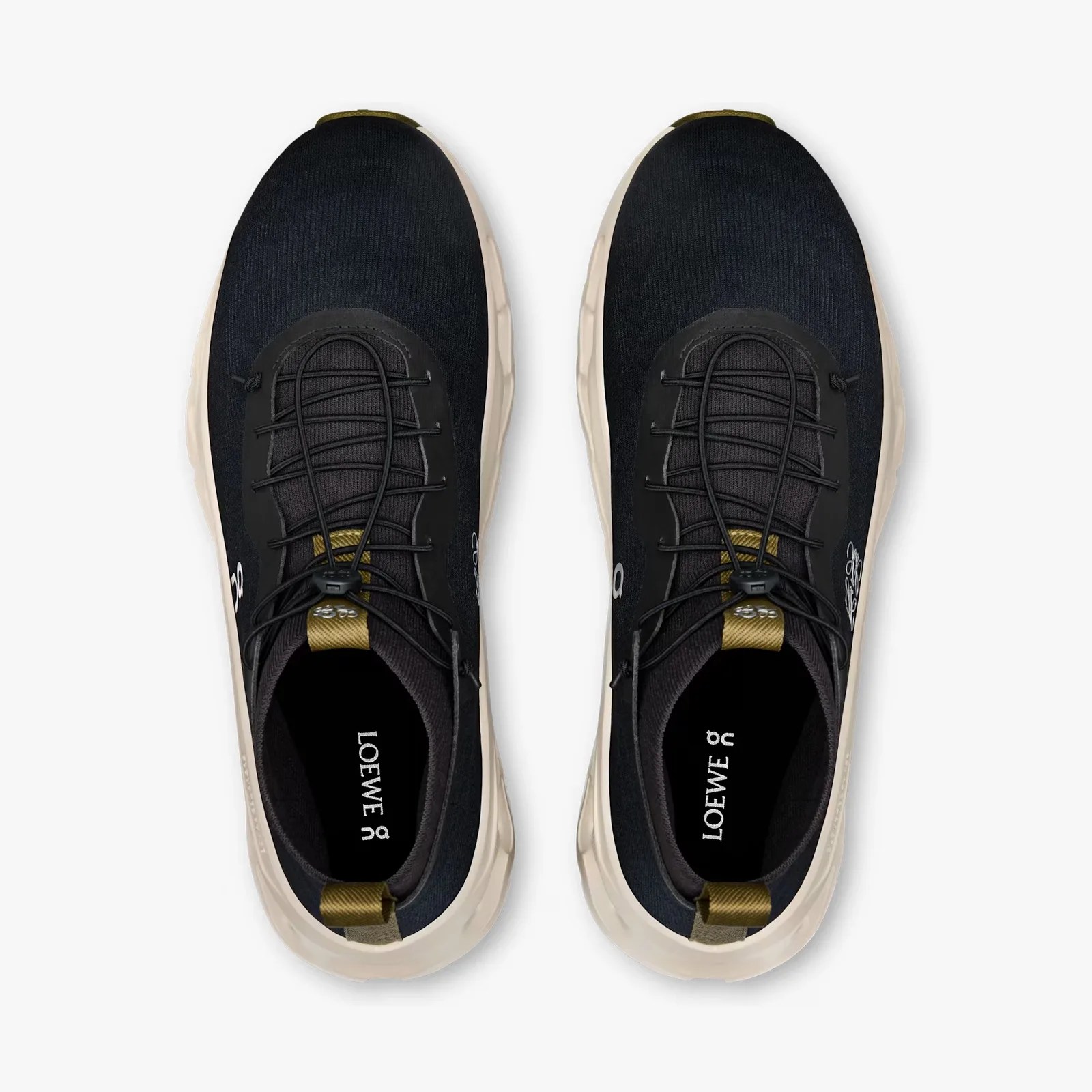 Pair of black athletic shoes with white soles and olive green pull tabs, viewed from above.