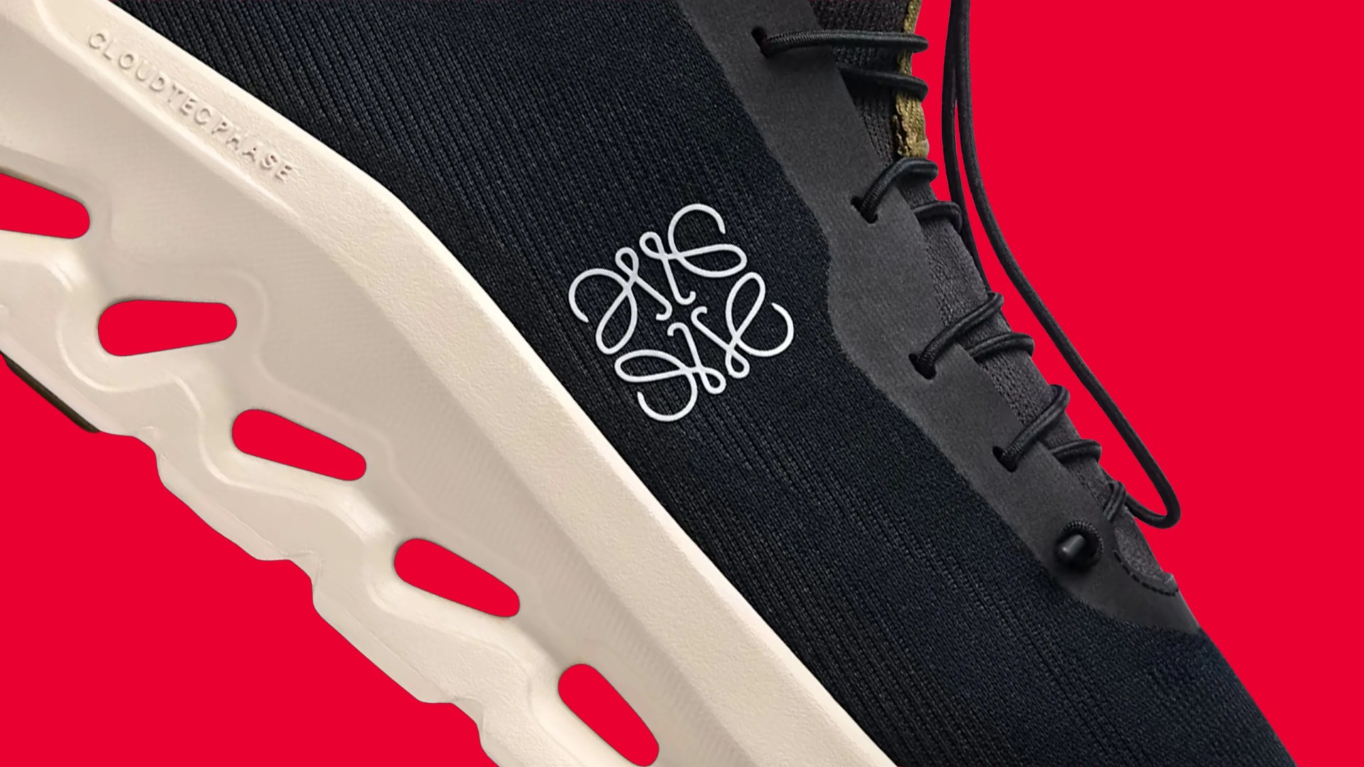 Close-up of a black sneaker with white sole featuring "CLOUDTEC PHASE" text and a white intricate logo on the side.
