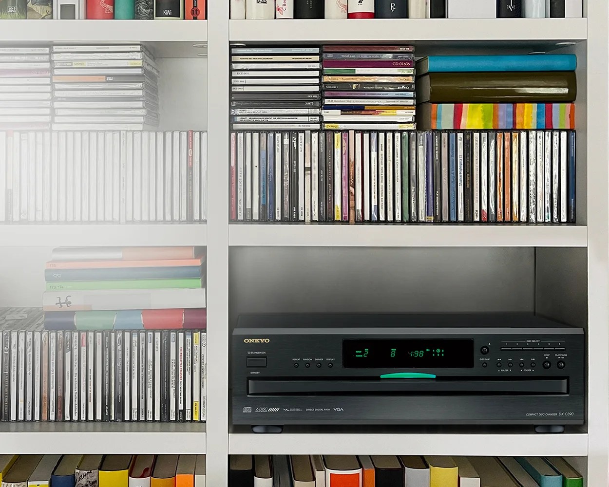 Black Onkyo DX-C390 compact disc changer with digital display in a white shelf surrounded by CDs and books.