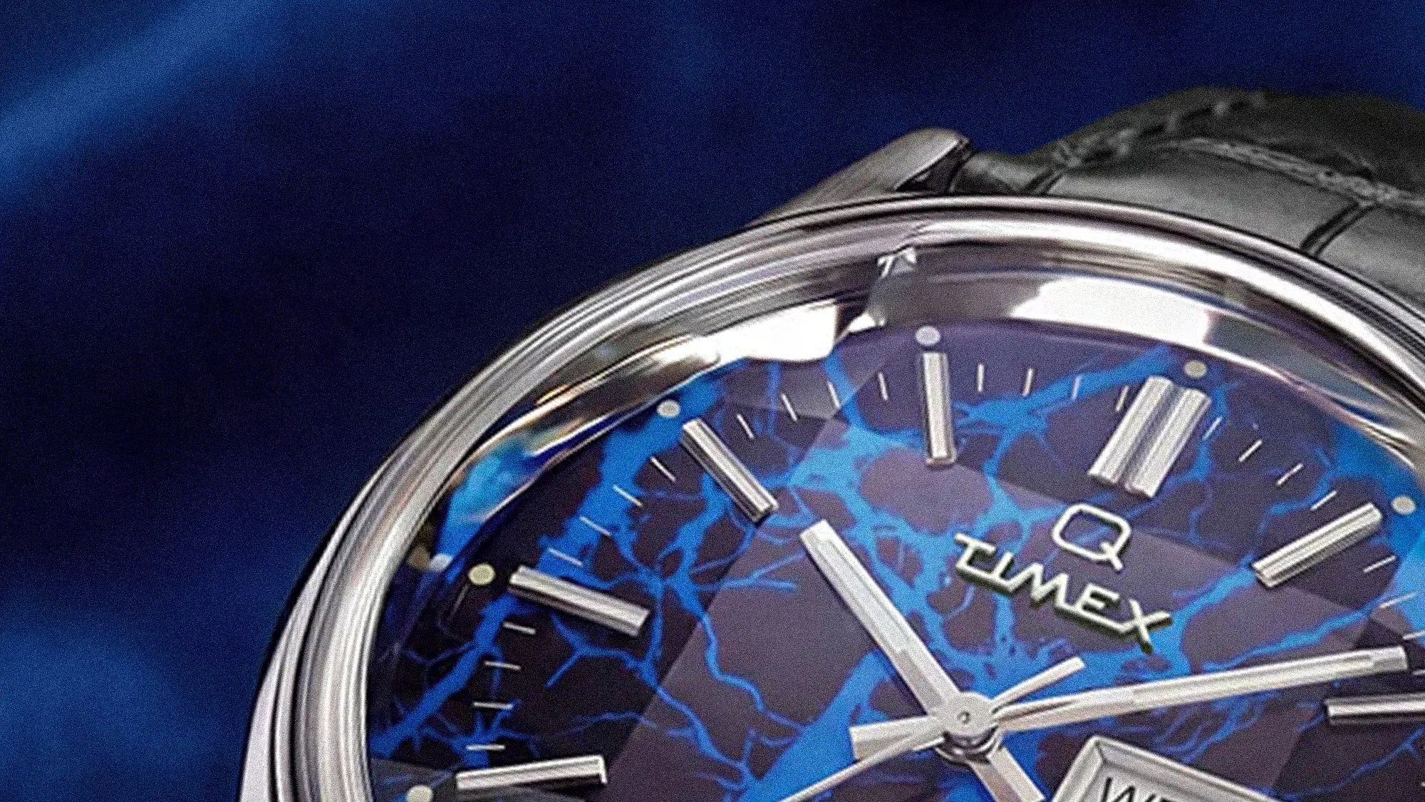 Close-up of a Timex watch face with blue and black marbled pattern and silver hour markers and hands.