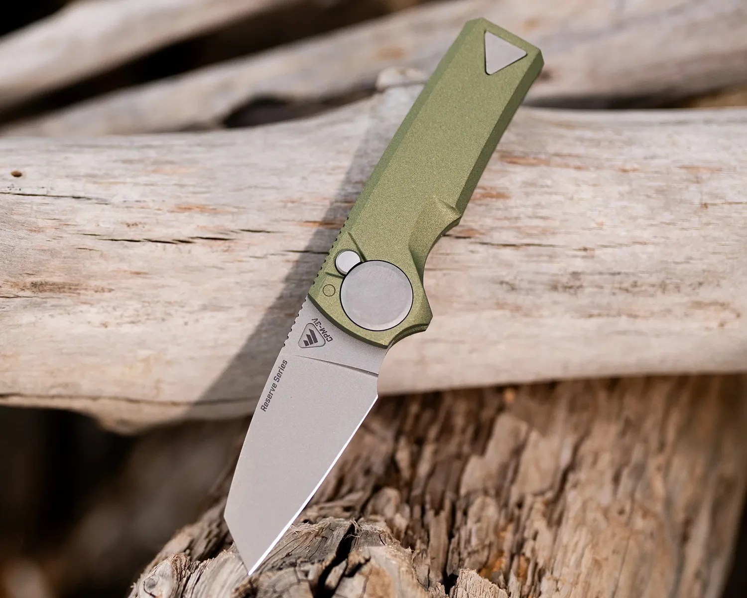 Folding knife with a green handle and a silver blade labeled "Reserve Series" resting on weathered wood.