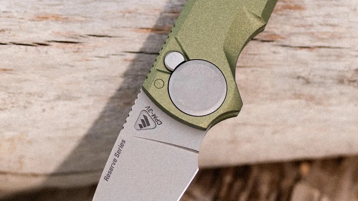 Close-up of a folding knife blade marked "Reserve Series" and "CPM-3V" with a green textured handle.