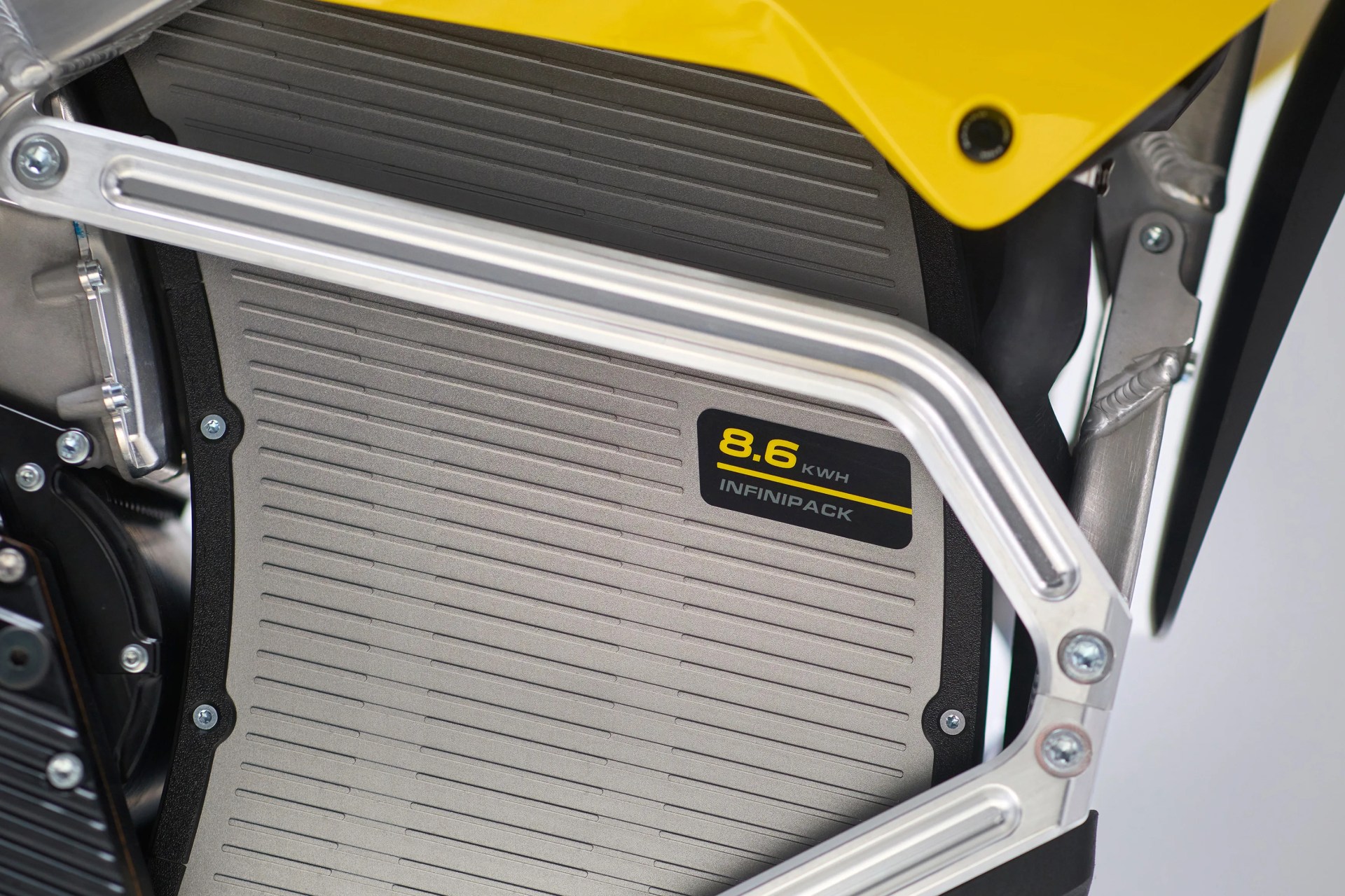 Close-up of a metallic 8.6 kWh Infinipack battery pack with a yellow frame and black components.