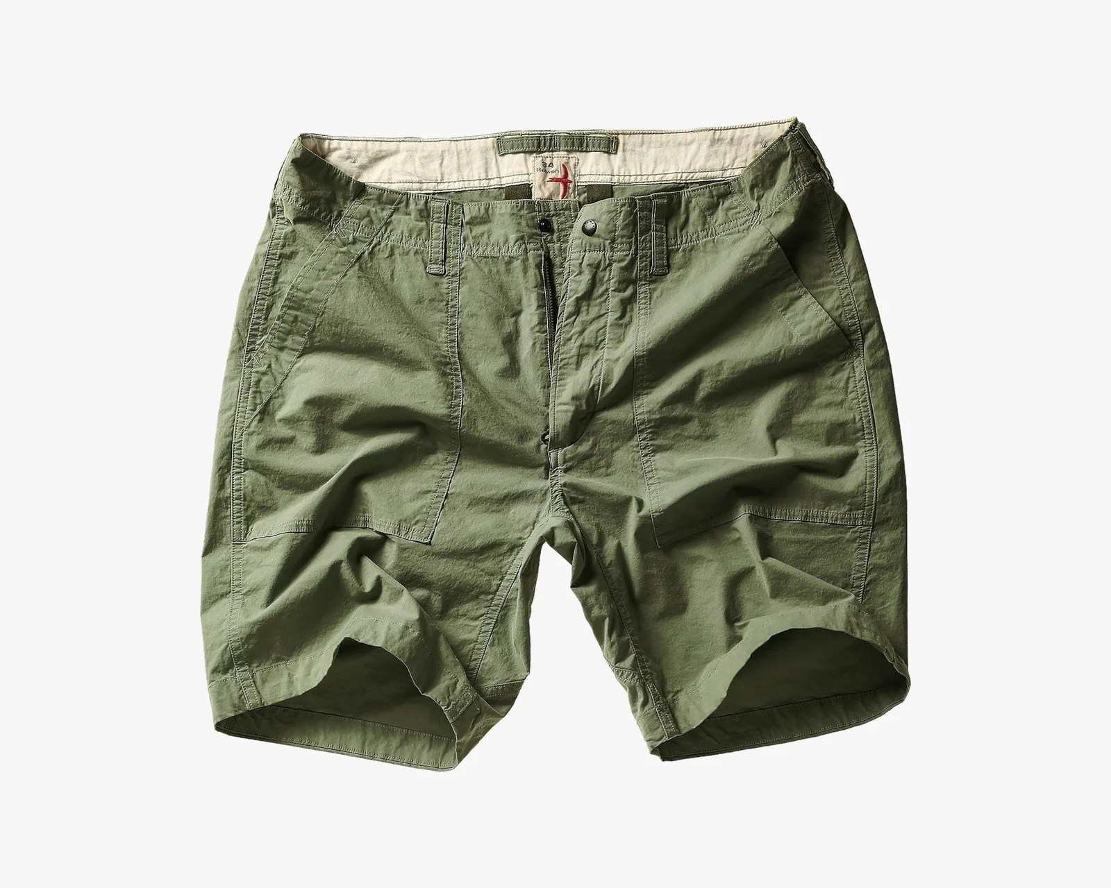 Olive green cotton shorts with front pockets and button closure laid flat on a white background.