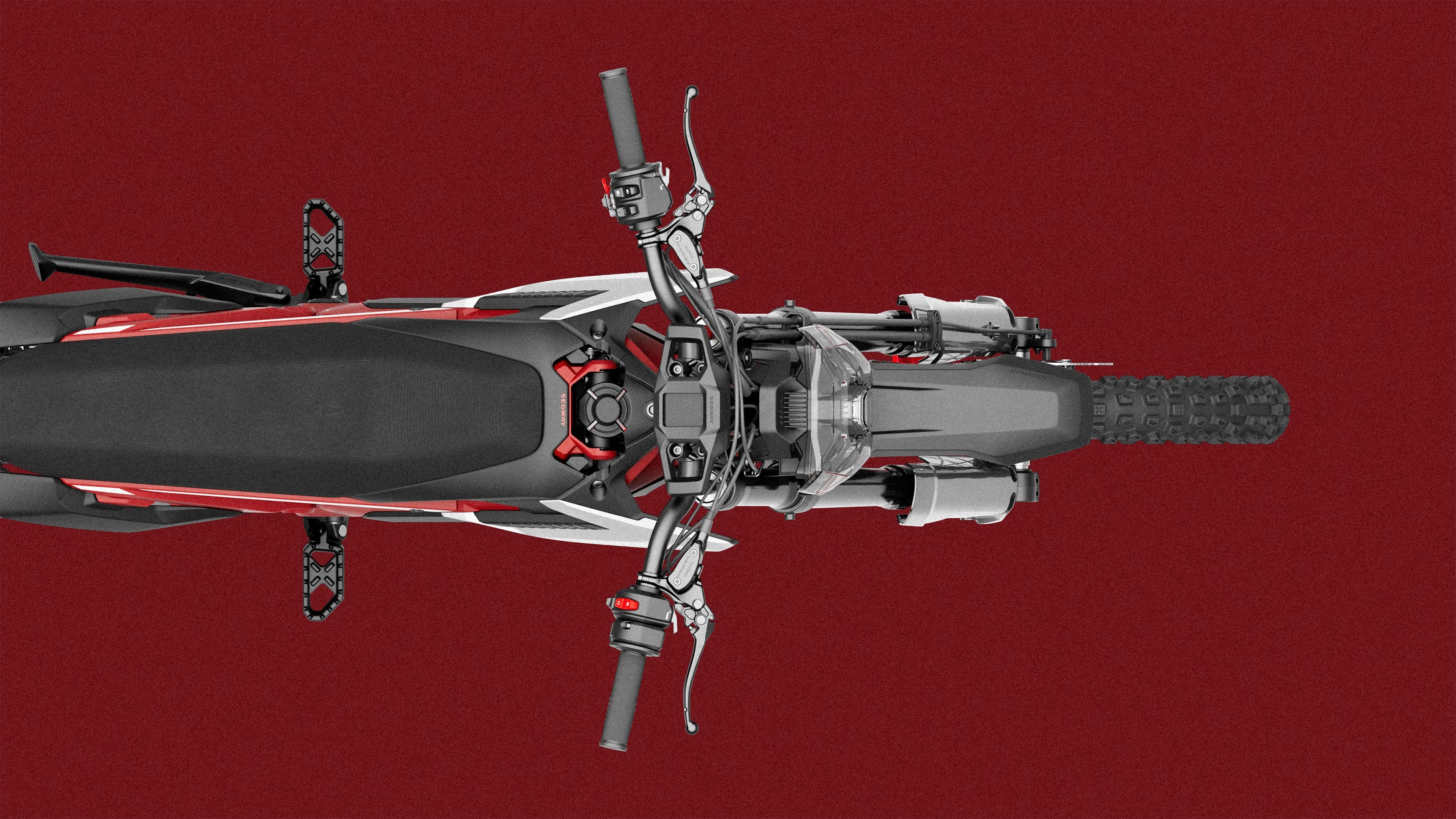 Top-down view of a red and black off-road motorcycle with knobby tires on a red background.