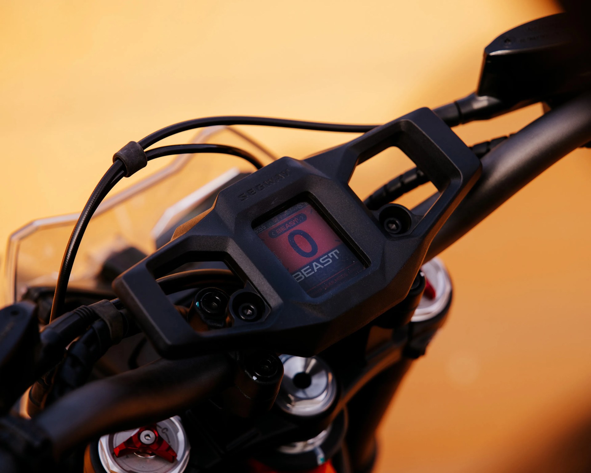 Close-up of a black Segway motorcycle handlebar with a digital display showing "BEAST" and the number 0.