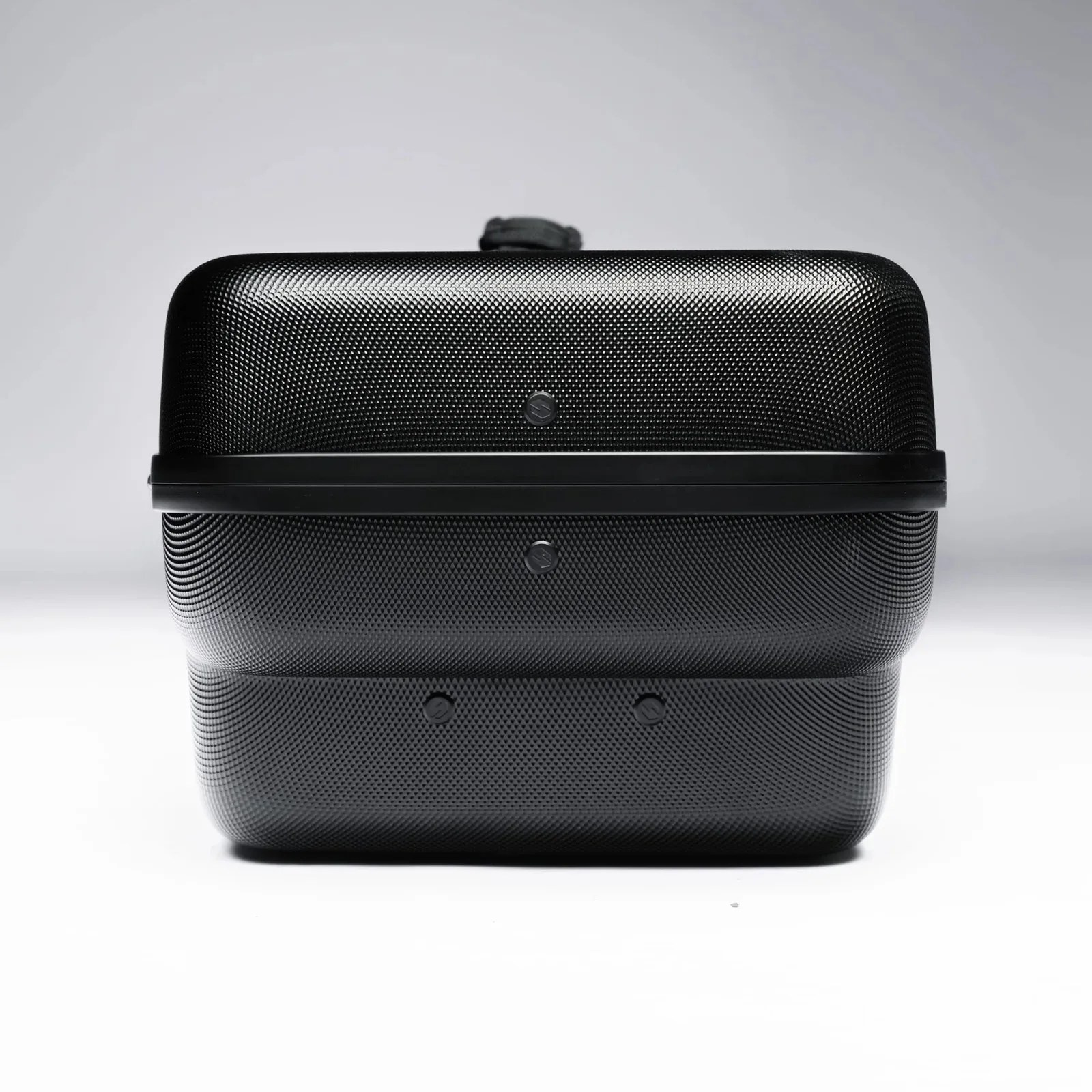 Black textured hard-shell suitcase with a horizontal strap and a handle on top.
