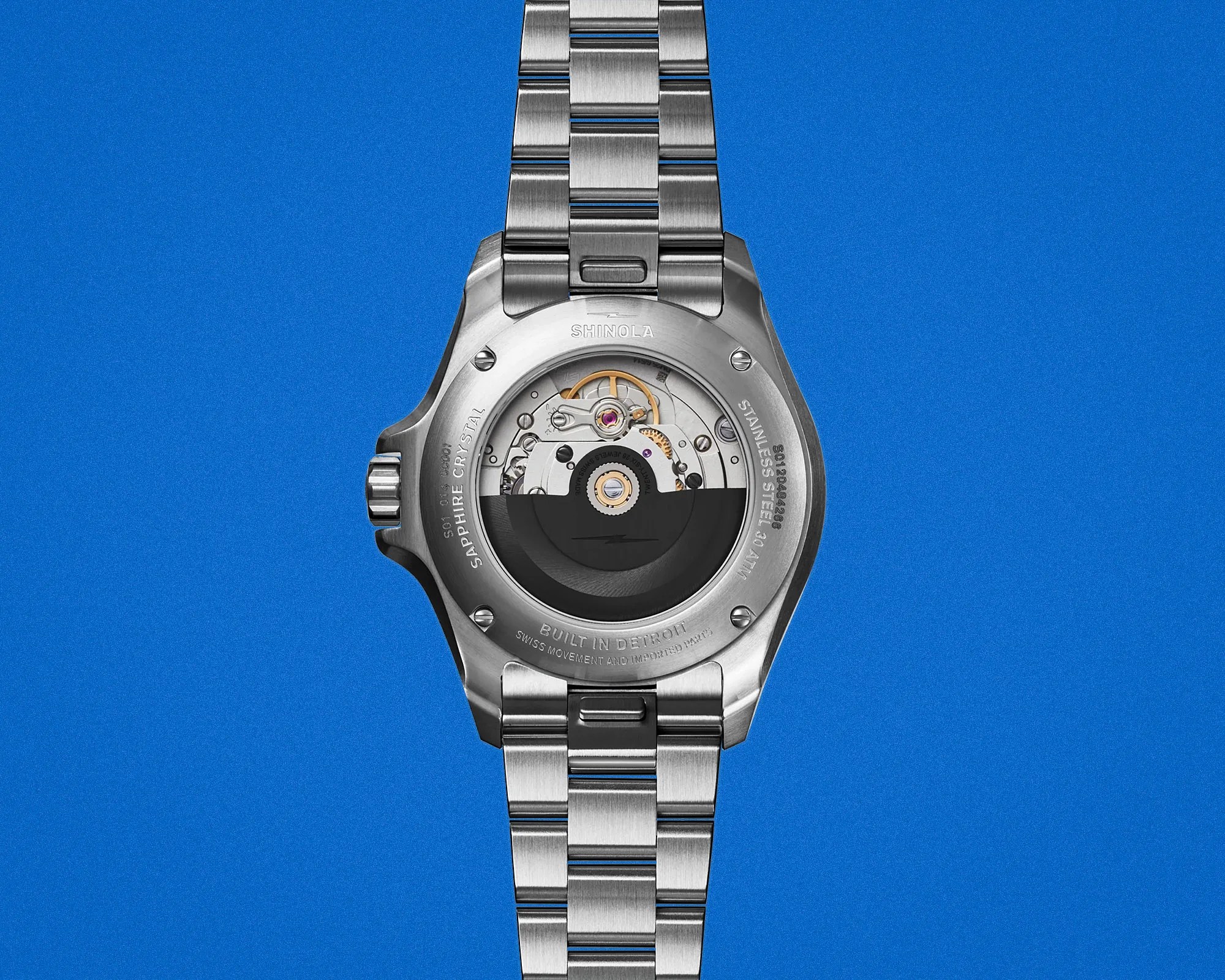 Back view of a Shinola stainless steel wristwatch with visible automatic movement and sapphire crystal case back.