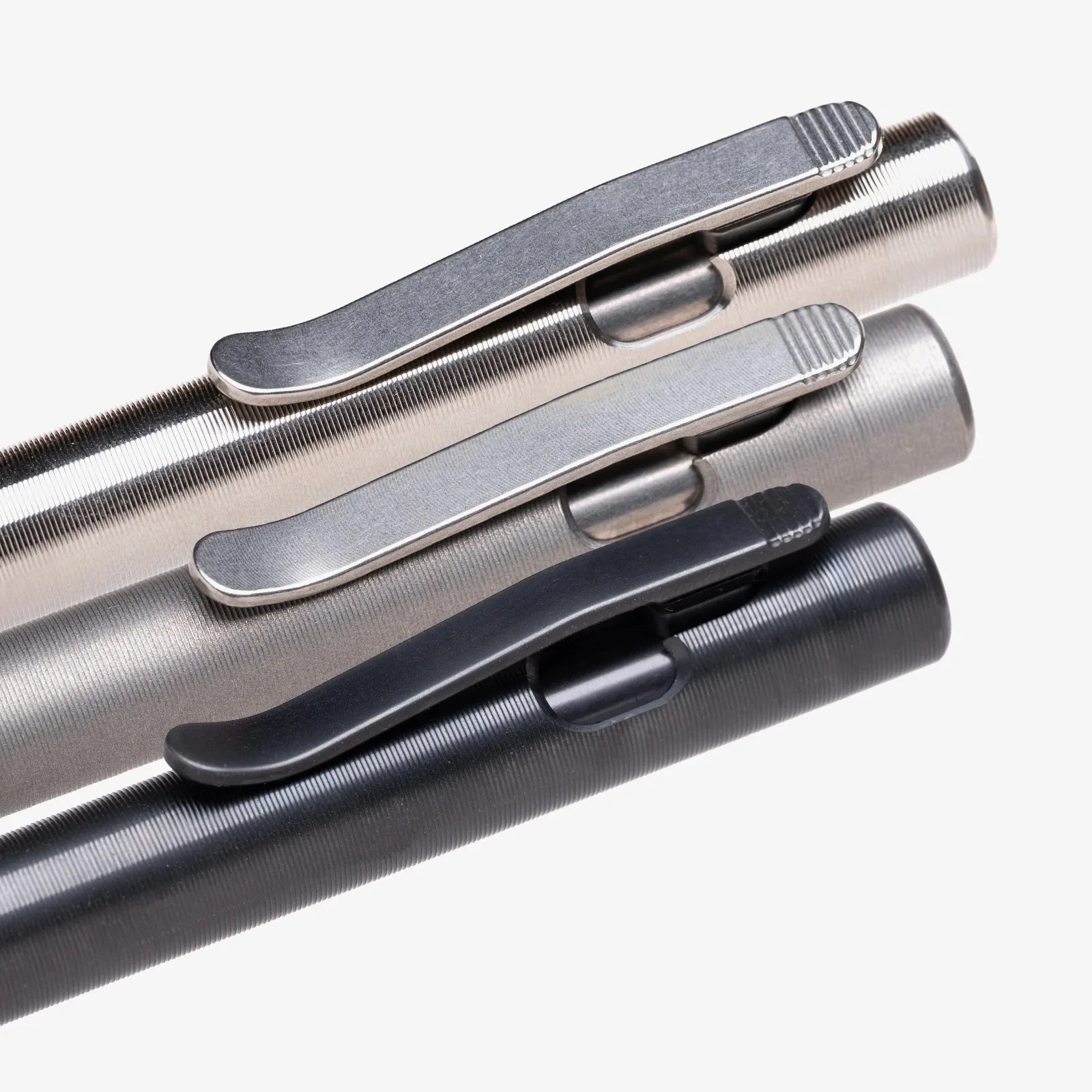 Three metal pens with textured bodies and clips, arranged diagonally in silver, gray, and black colors.