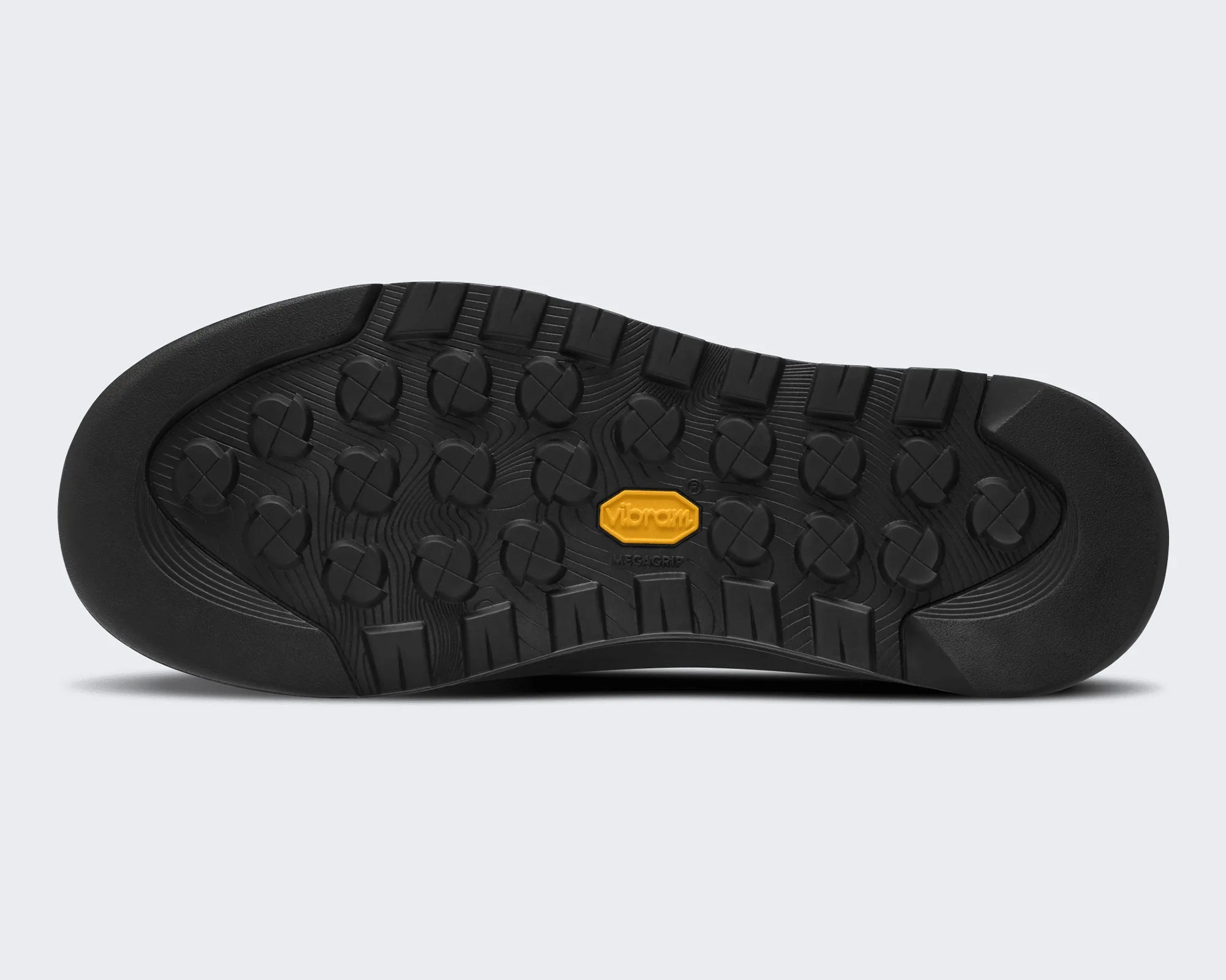 Black Vibram Megagrip rubber outsole with circular and rectangular tread patterns.