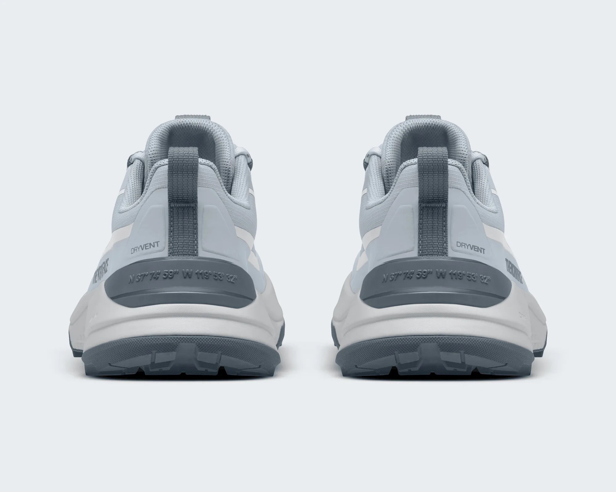 Pair of light gray athletic shoes with dark gray heel pull tabs and soles, viewed from the back.
