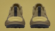 Pair of tan hiking shoes with black pull tabs and yellow heel accents showing coordinates on the back.