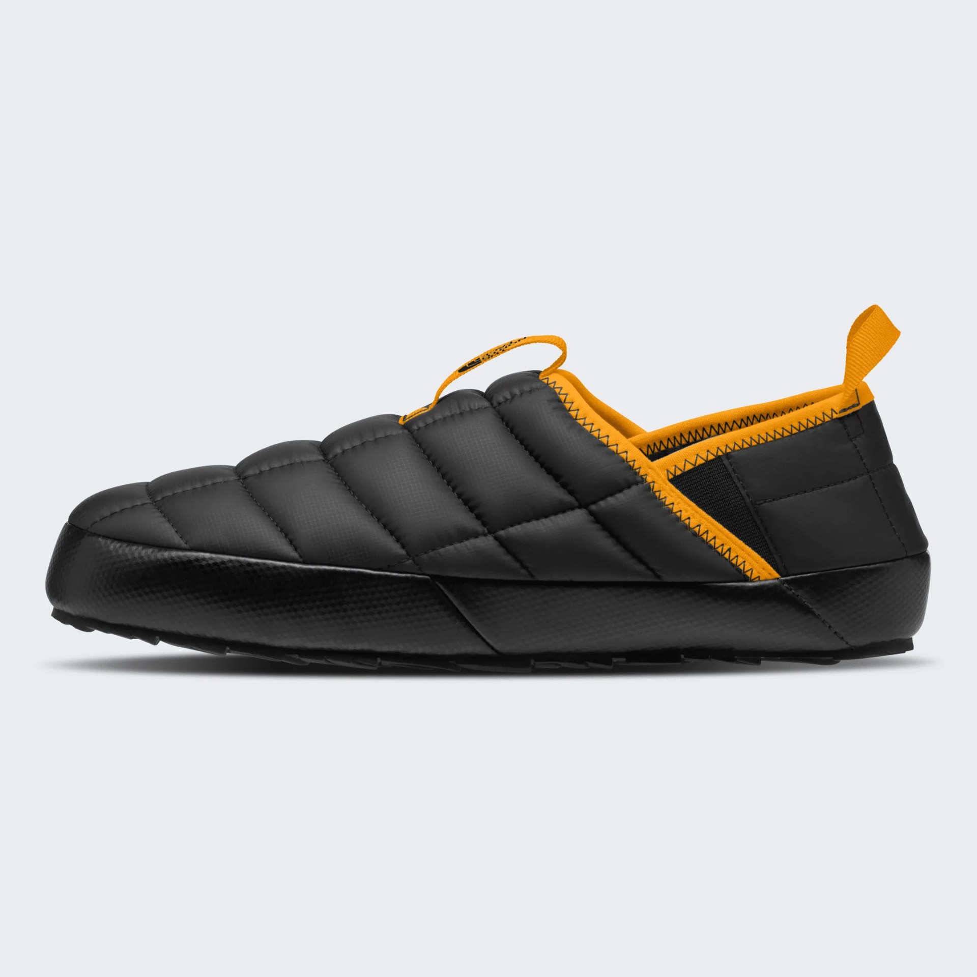 Black quilted slip-on shoe with orange trim and pull tabs.