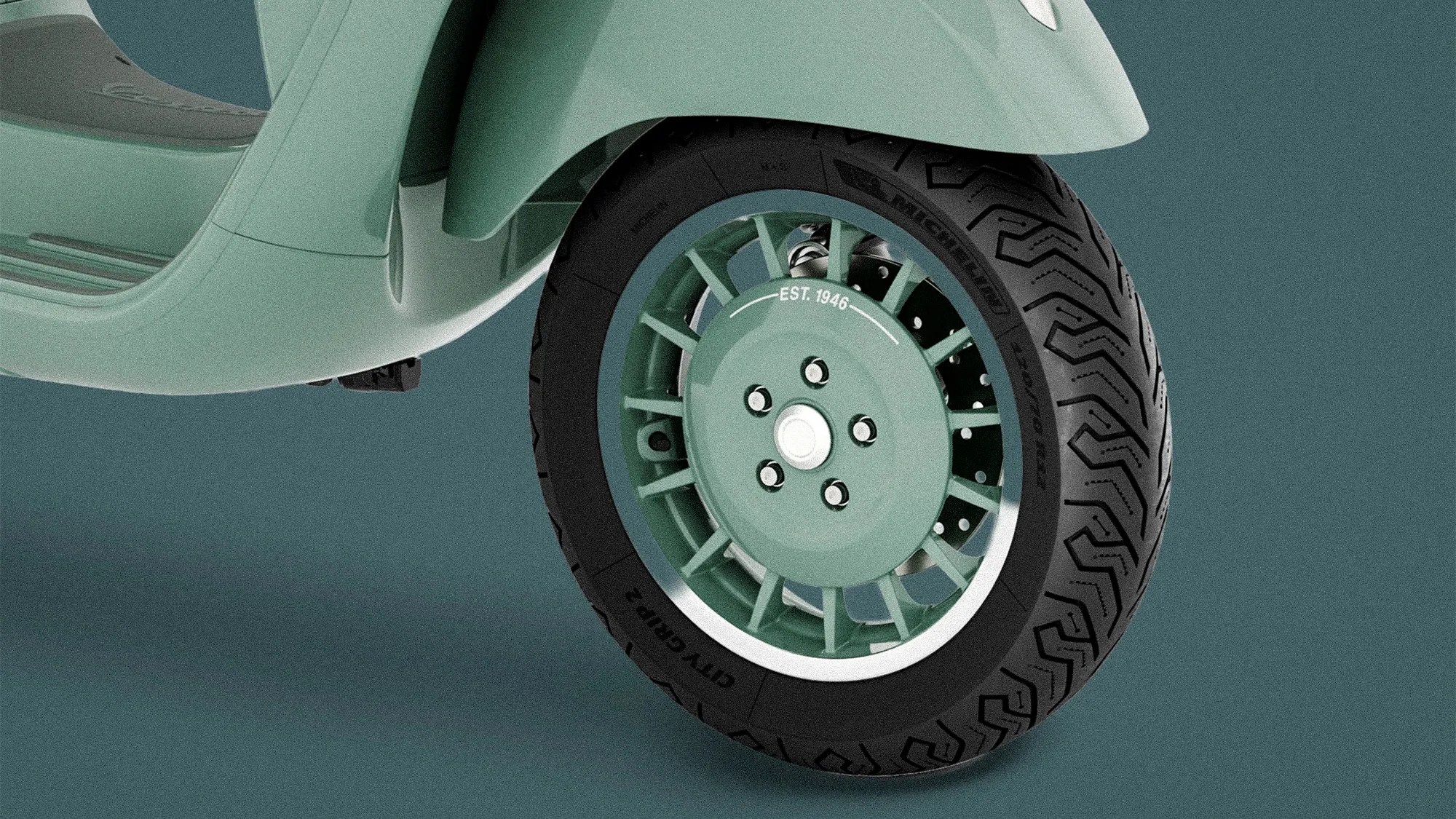 Close-up of a green scooter front wheel with Michelin City Grip 2 tire and "EST. 1946" text on the hub.