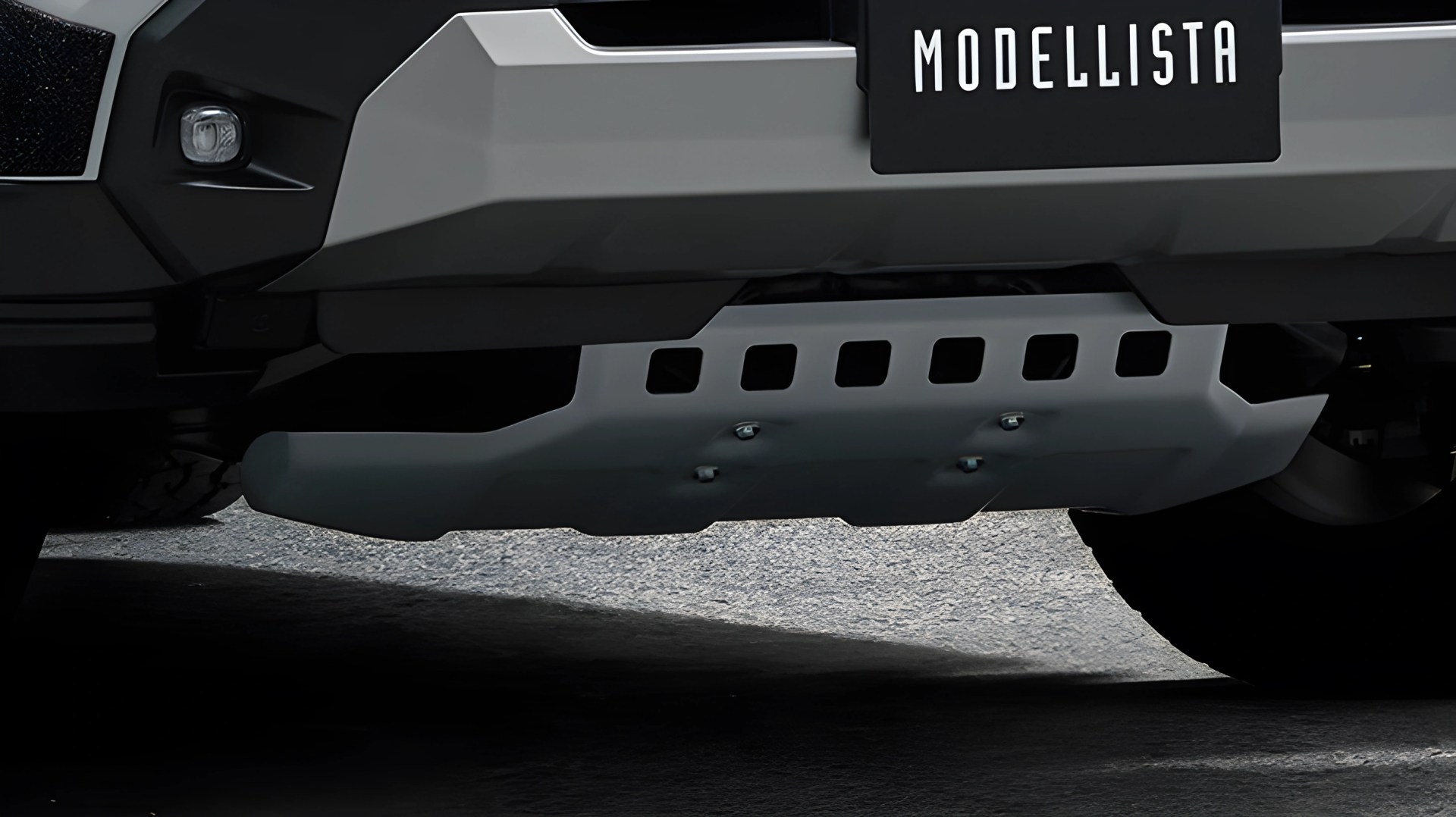 Gray skid plate attached to the underside of a vehicle with a "MODELLISTA" license plate above.