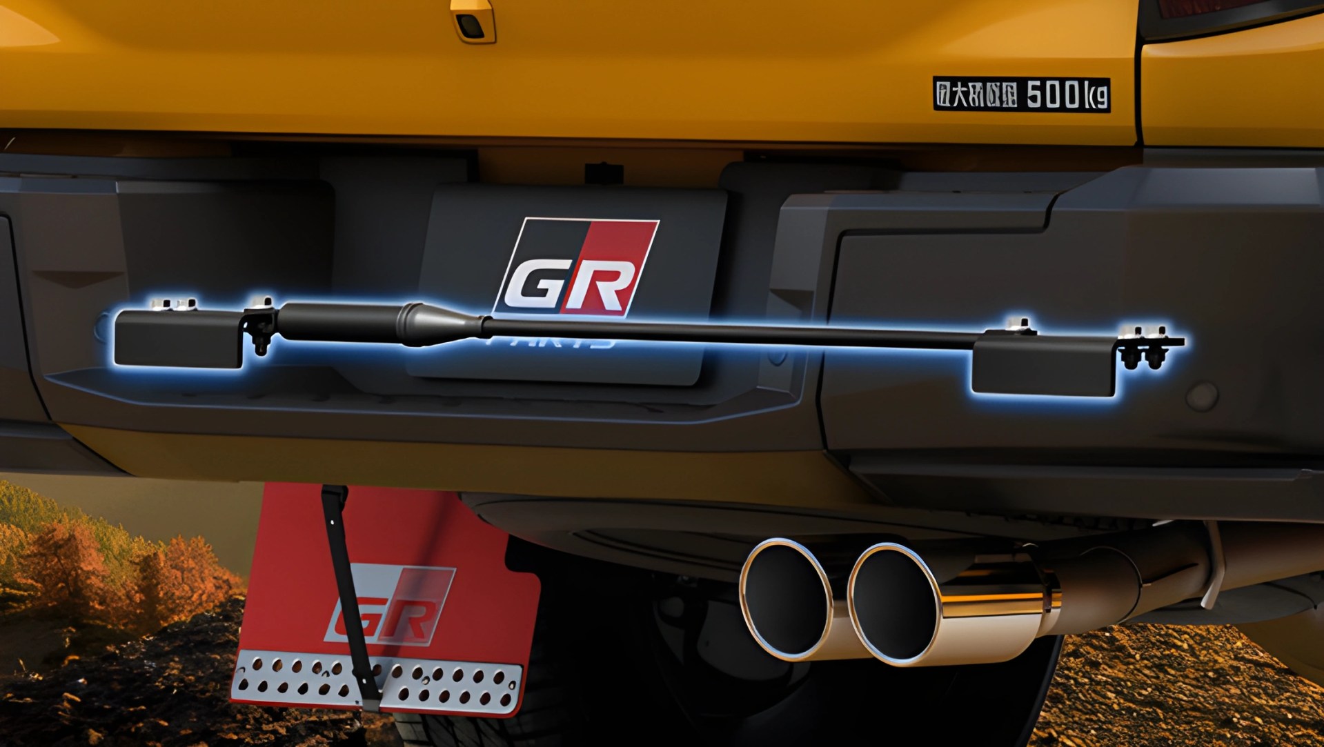 Close-up of a black rear bumper bar mounted on a yellow vehicle with dual chrome exhaust pipes and a red GR mud flap.
