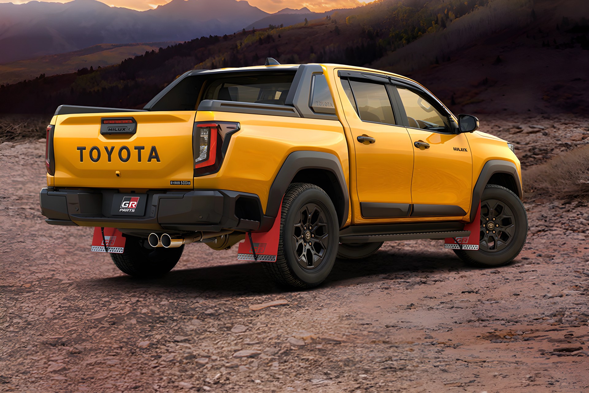 Yellow Toyota Hilux pickup truck with black wheels and red mud flaps on a rocky terrain at sunset.