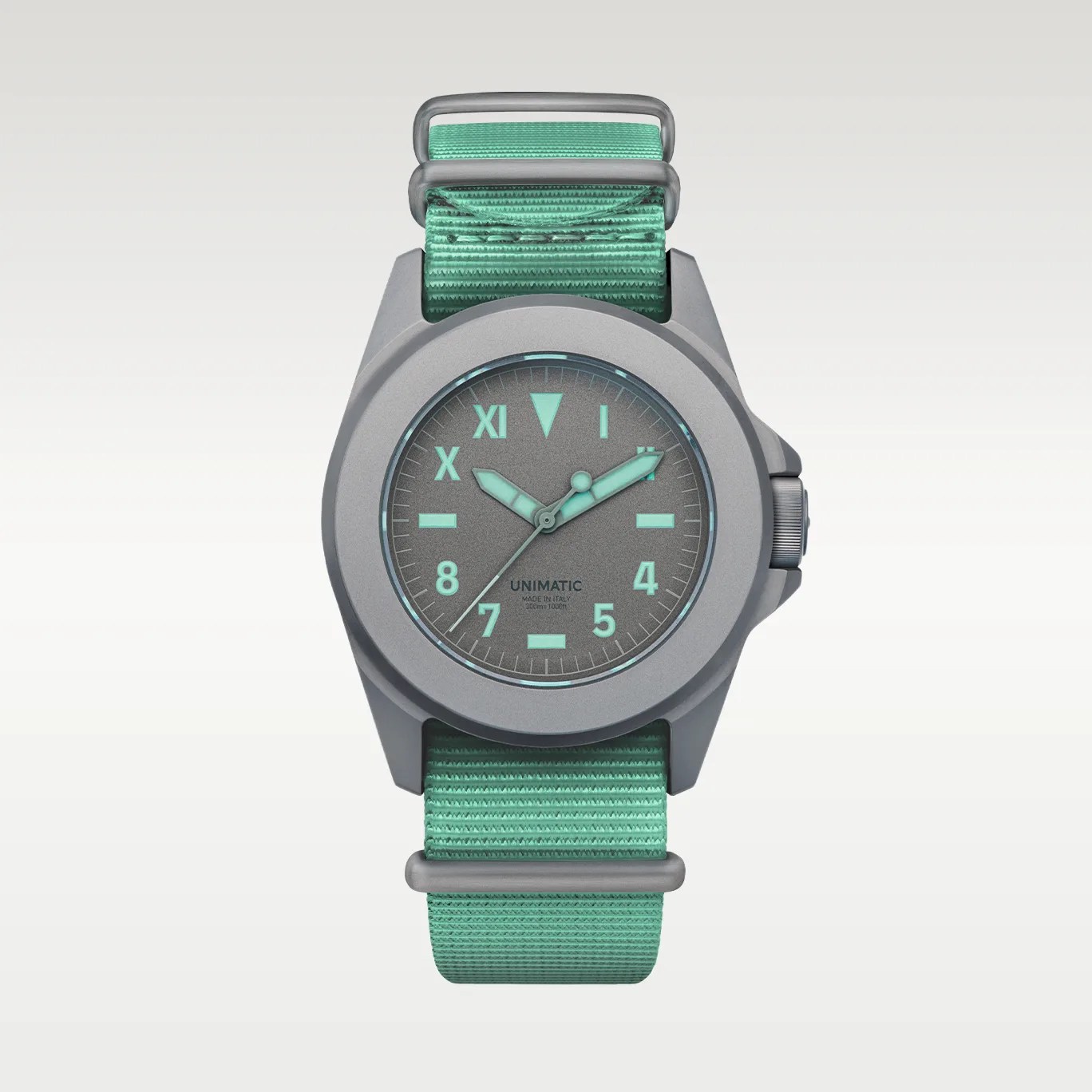 Gray Unimatic watch with mint green fabric strap and matching mint green hour markers and hands.