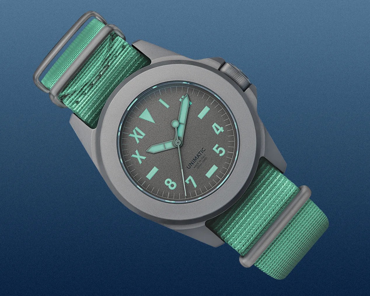 Matte gray Unimatic wristwatch with mint green luminescent hands and markers on a matching green nylon strap.