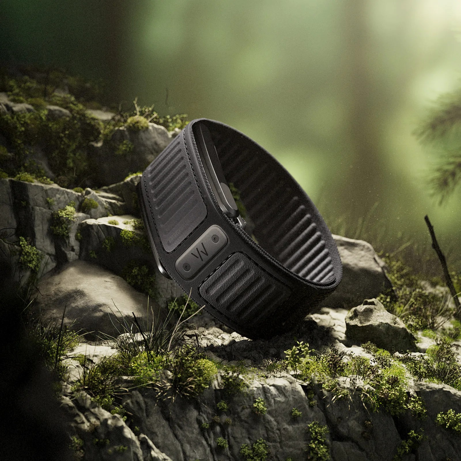 Black textured wristband with a rectangular clasp featuring the letters "VW" resting on mossy rocks.