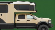 Side view of a beige and black off-road truck camper with a green background.