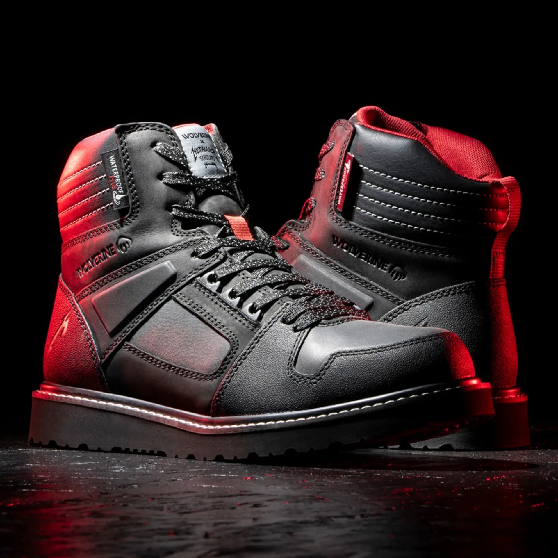 Black and red Wolverine waterproof leather boots with black laces on a dark surface.