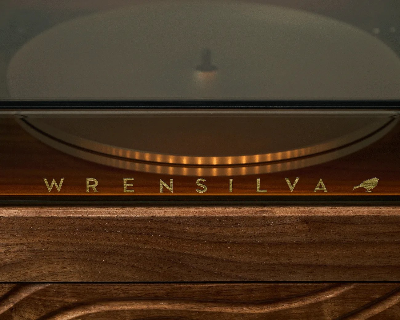 Close-up of a wooden surface with the word "WRENSILVA" and a bird logo in gold lettering.