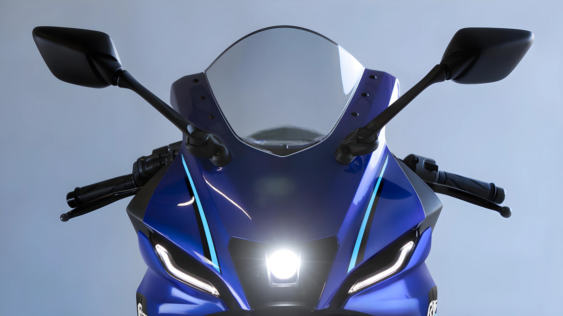Front view of a blue sport motorcycle with black side mirrors, clear windshield, and illuminated headlights.