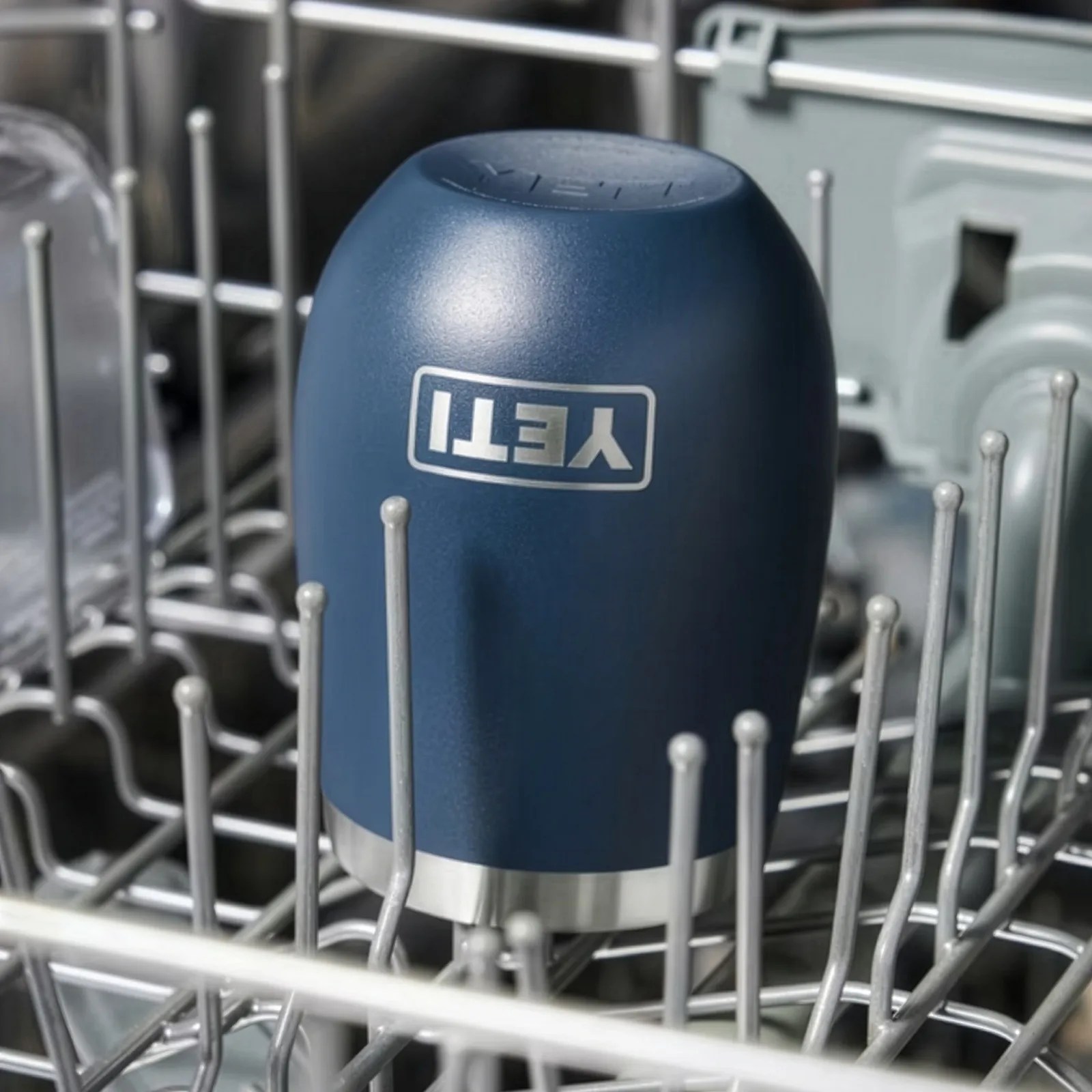 Blue YETI tumbler upside down in a dishwasher rack.