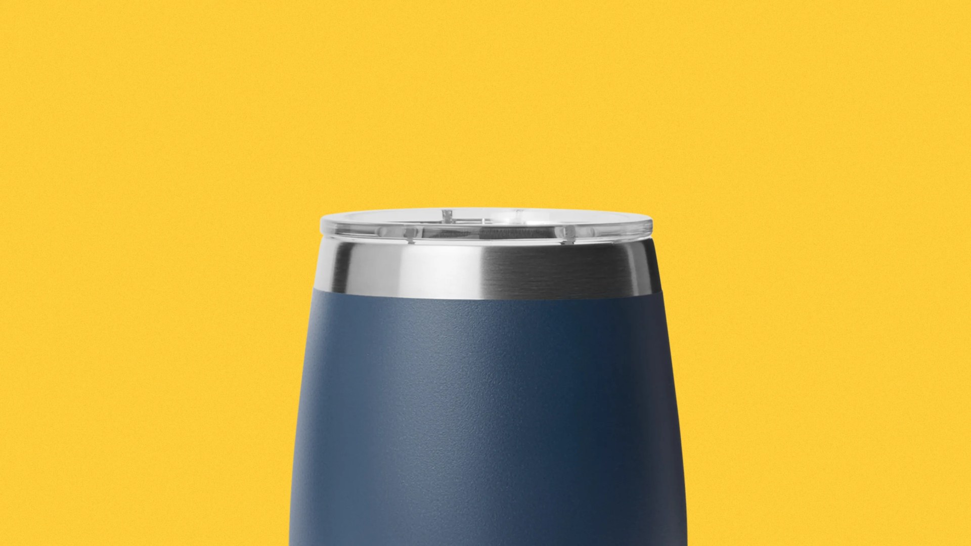 Blue stainless steel tumbler with clear plastic lid against a yellow background.