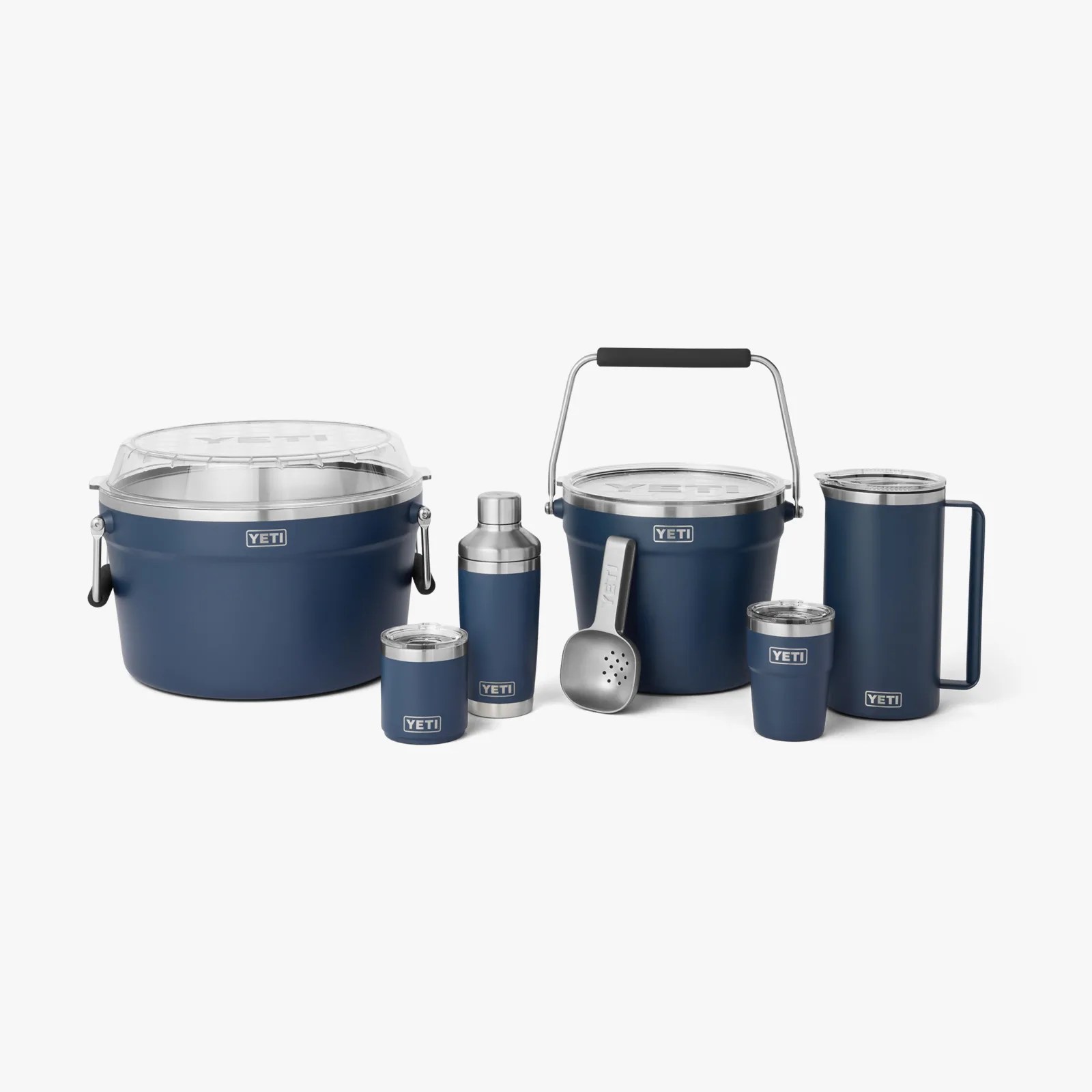 Set of navy blue YETI insulated drinkware and coolers including two coolers, two tumblers, a shaker, a pitcher, and a scoop.