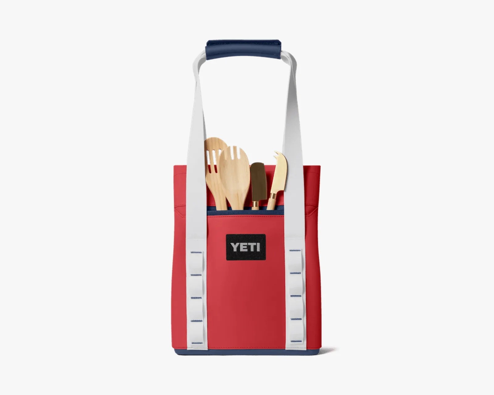 Red YETI tote bag with white straps and wooden kitchen utensils in front pocket.