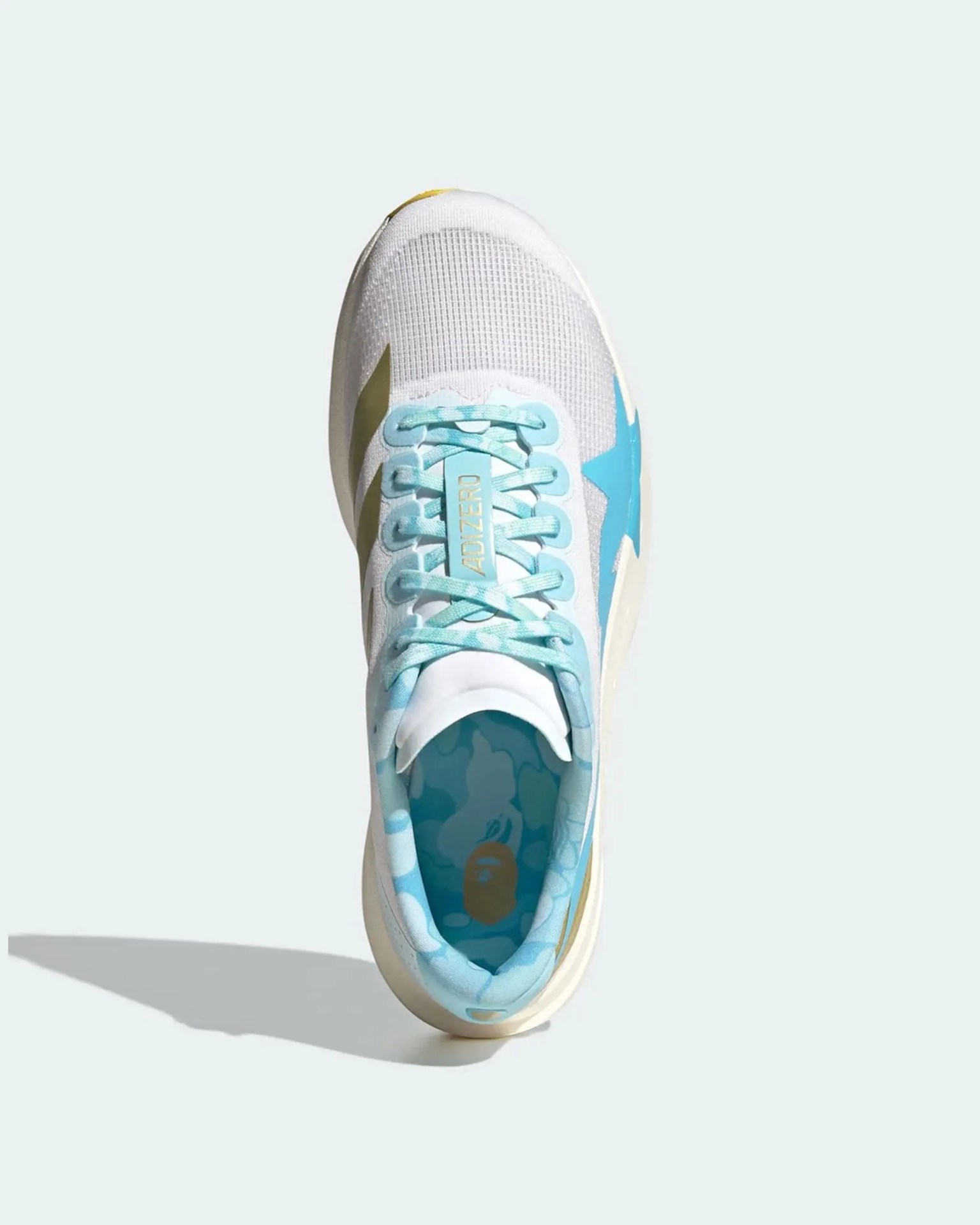 White and light blue sneaker with "ADIZERO" on the tongue and a blue star on the side.