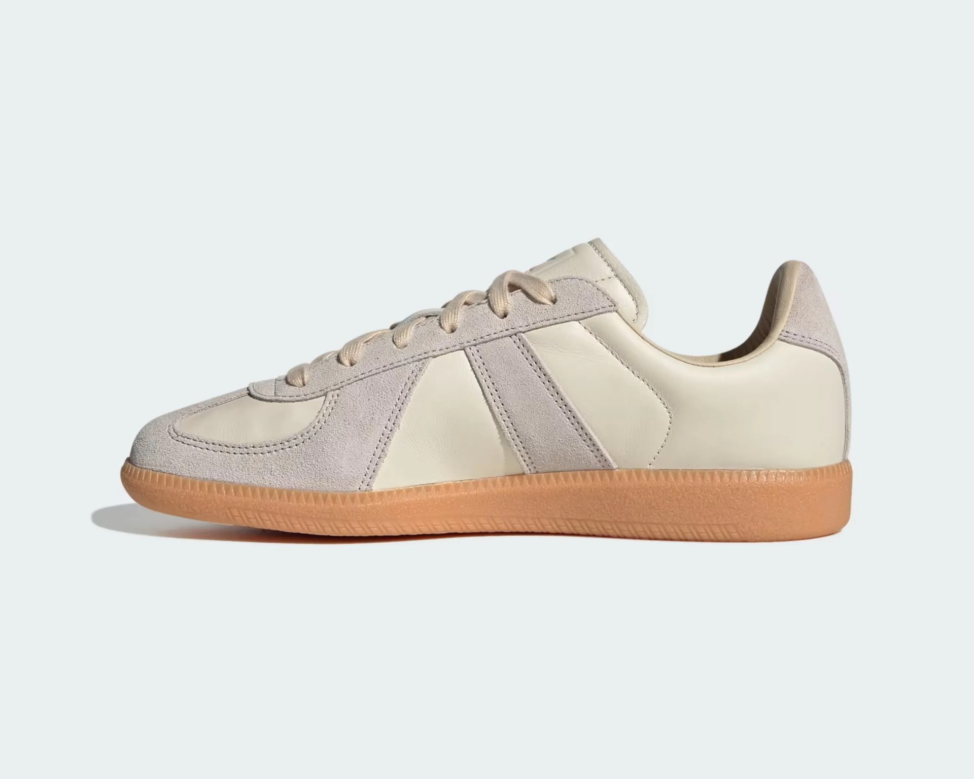 Beige and light gray suede and leather sneaker with gum sole on a white background.