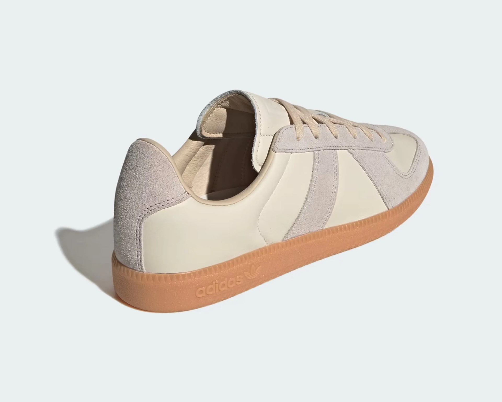 Beige and light gray suede Adidas sneaker with gum sole and embossed logo on the side.