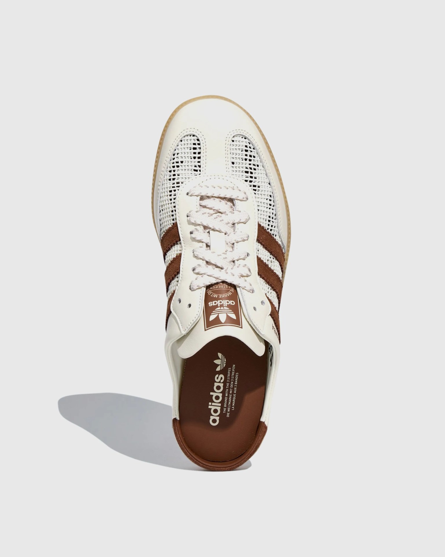 White and brown Adidas sneaker with woven mesh upper and leather toe cap viewed from above.