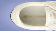Close-up of beige sneaker interior with "New Balance Aimé Leon Dore" branding on the insole.
