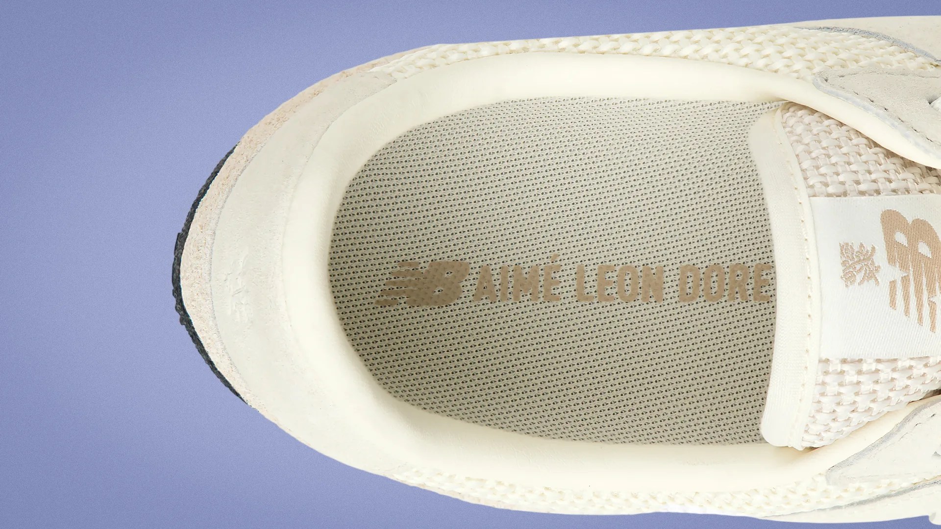 Close-up of beige sneaker interior with "New Balance Aimé Leon Dore" branding on the insole.