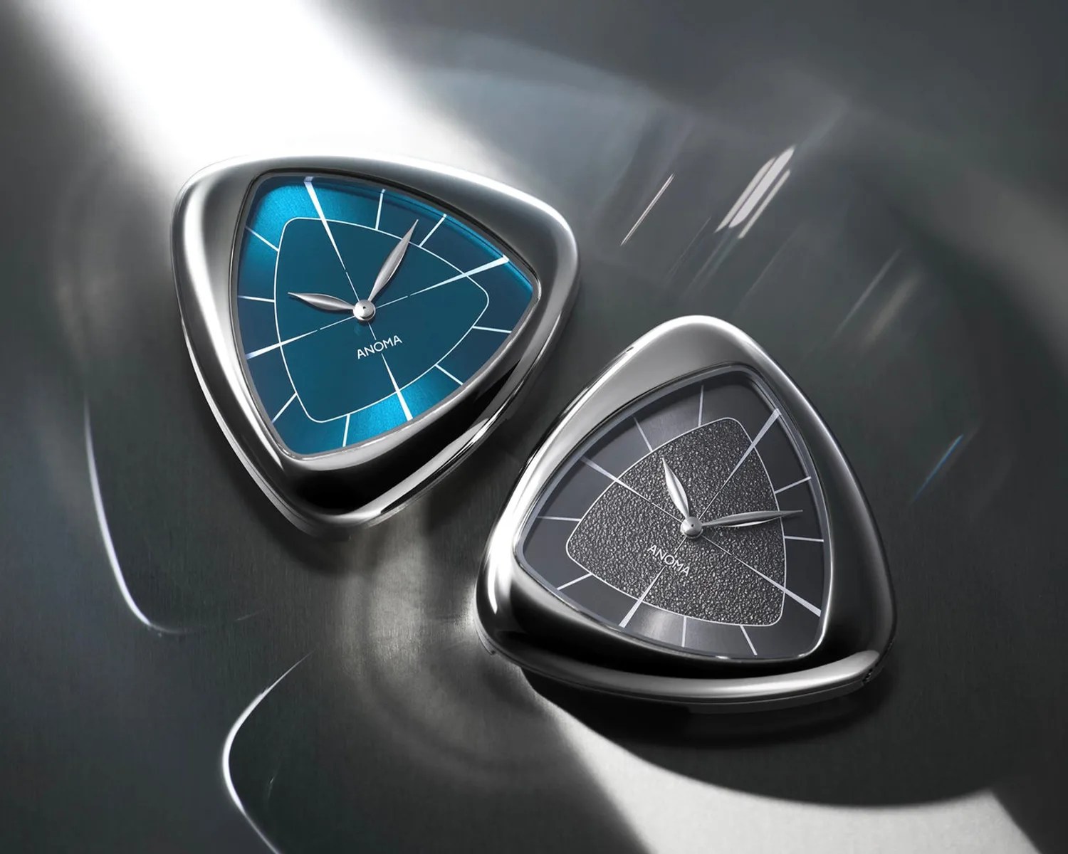 Two triangular-shaped wristwatches with silver cases, one with a blue dial and the other with a black textured dial, on a reflective surface.