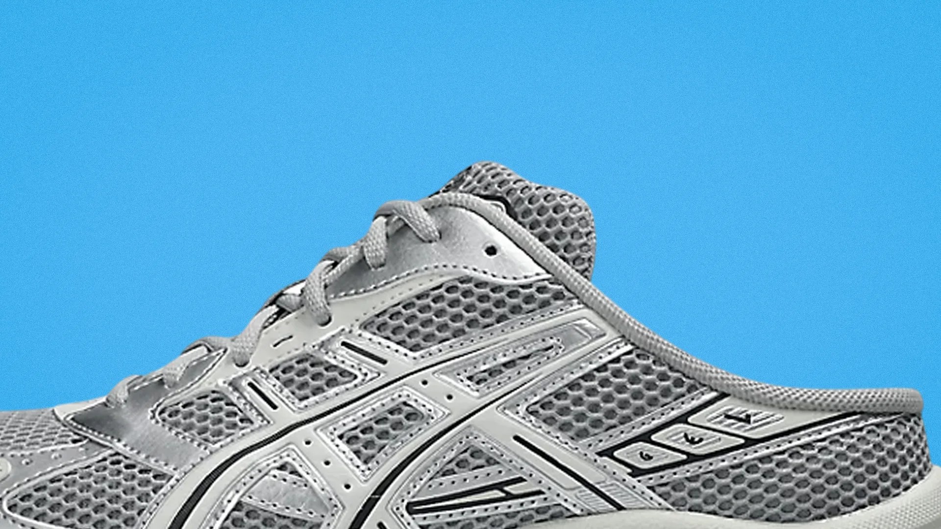 Gray mesh running shoe with synthetic overlays and laces against a blue background.