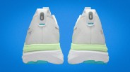 Pair of white running shoes with light green midsoles and blue accents shown from the back on a blue background.