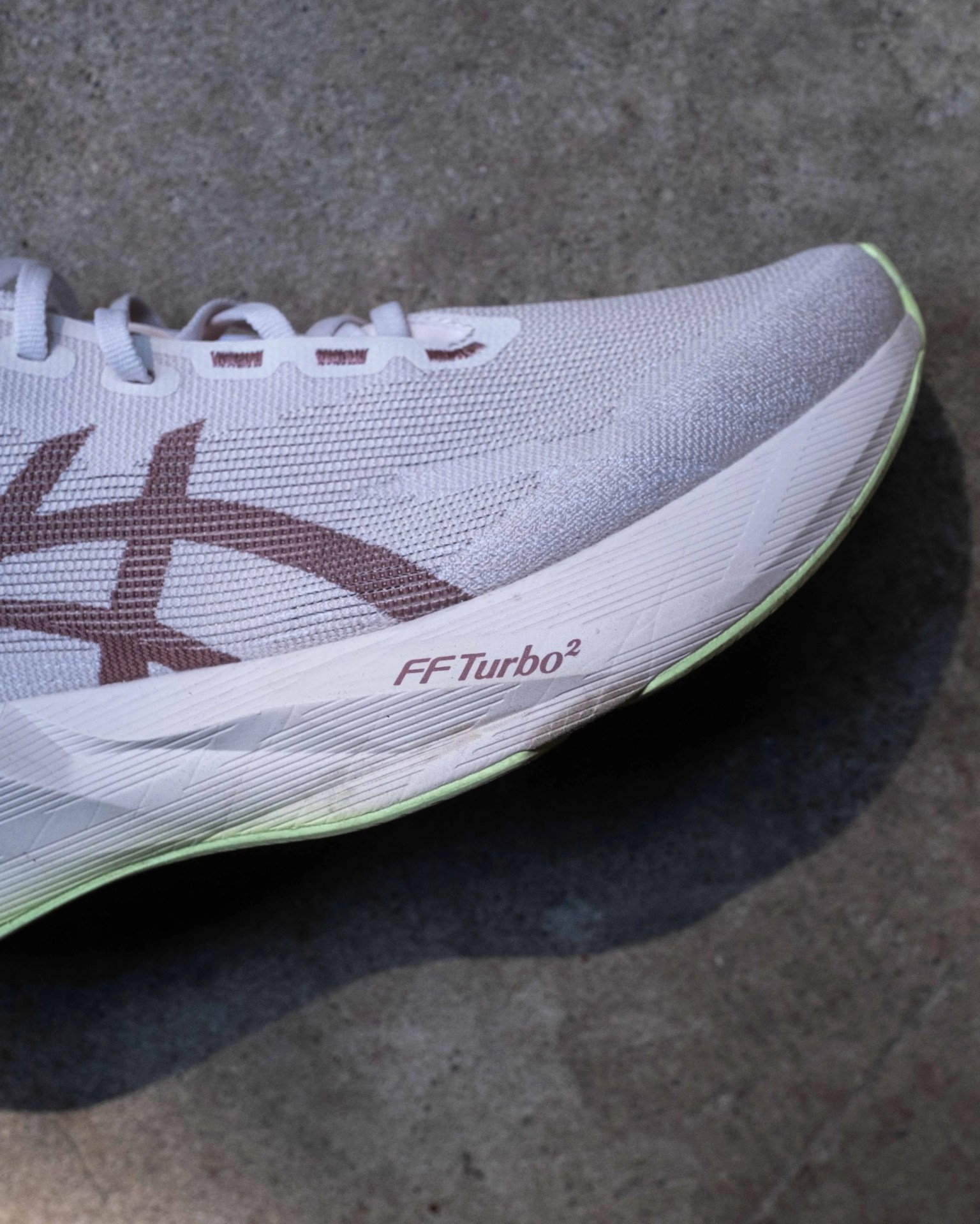 White and light green Asics running shoe with "FF Turbo²" text on the sole.